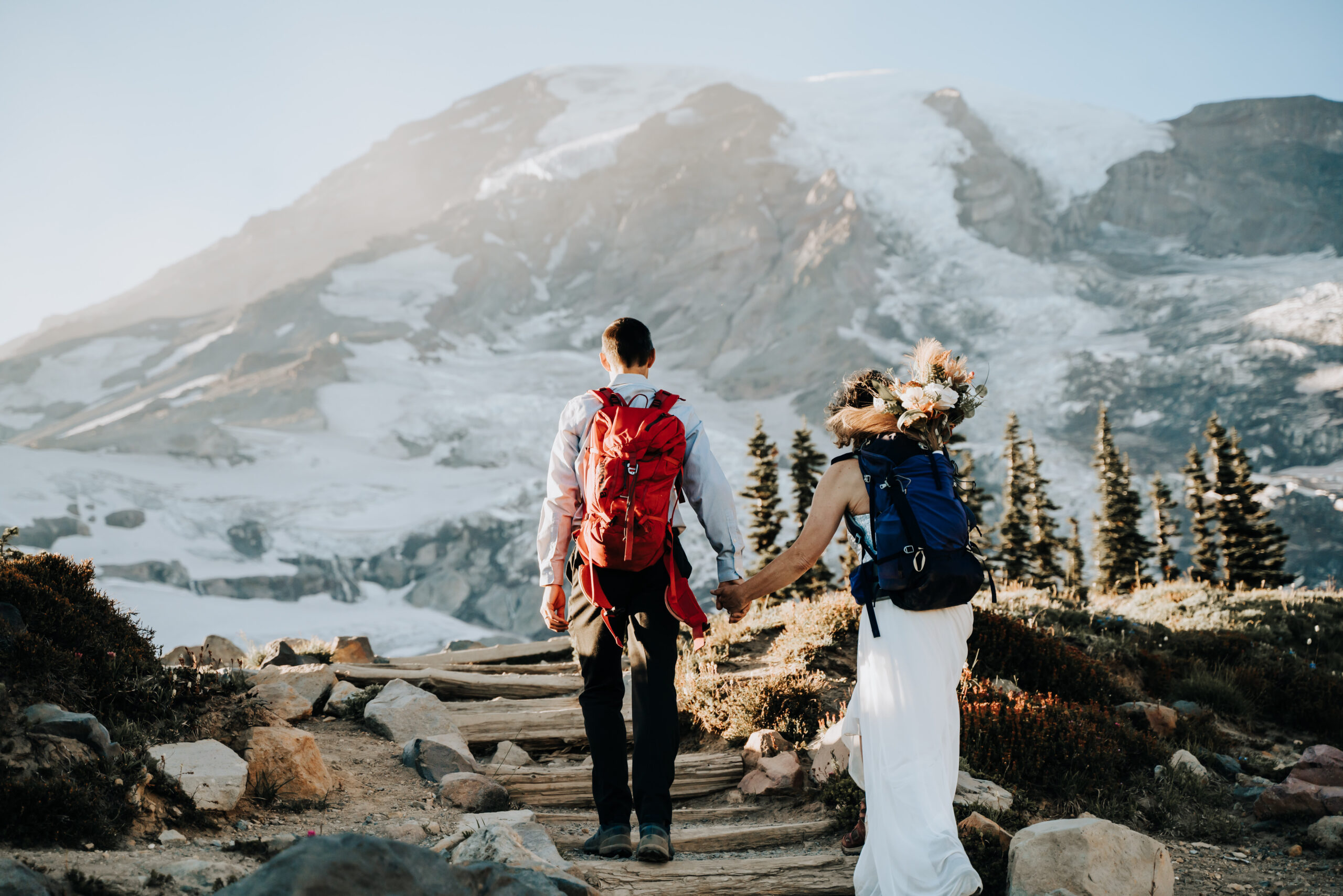 a wedding couple hiking up to panorama point in Mount Rainier for their elopement day