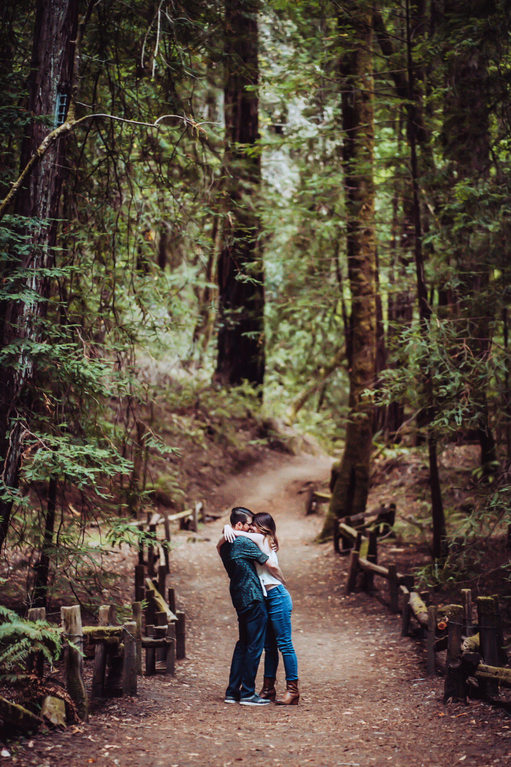 a couple hugging in the middle of the tall trees in northern California for their mini moon
