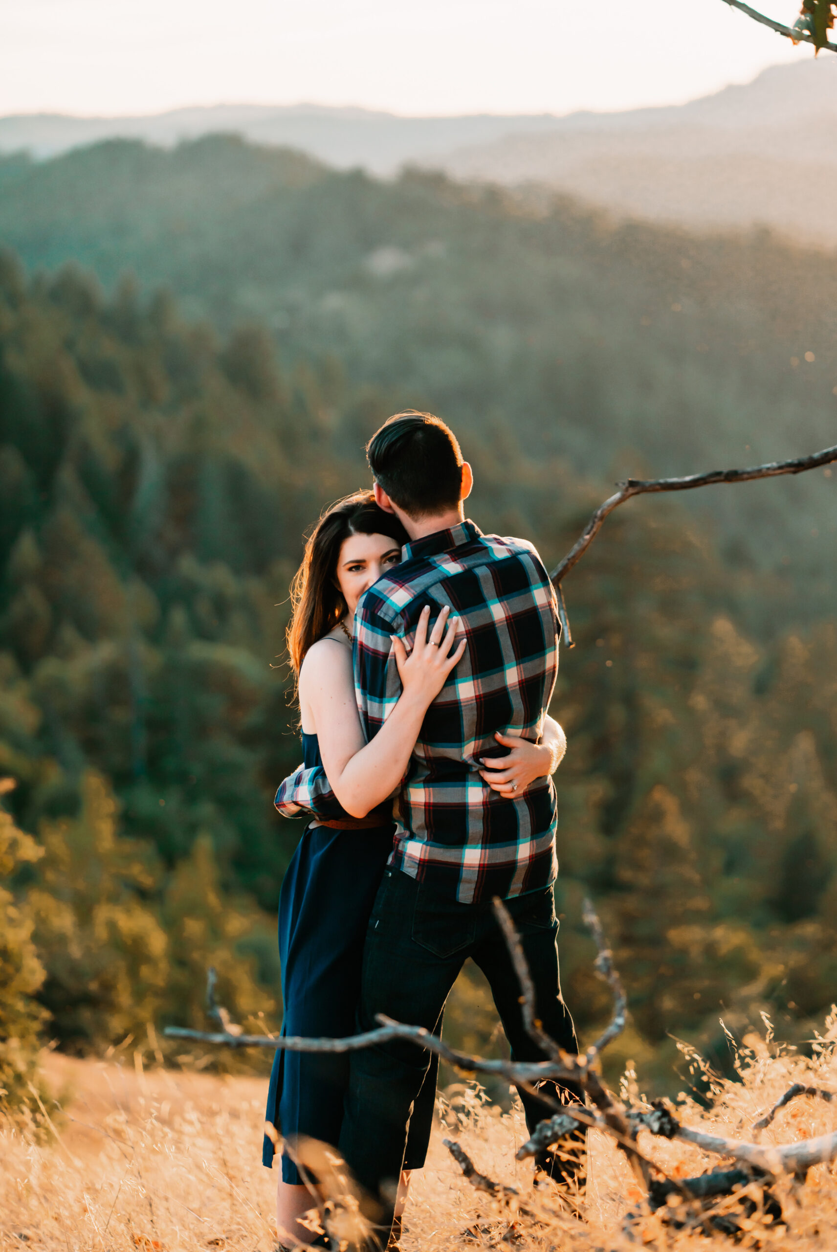 a couple hugging with mountains and sunset backdrop