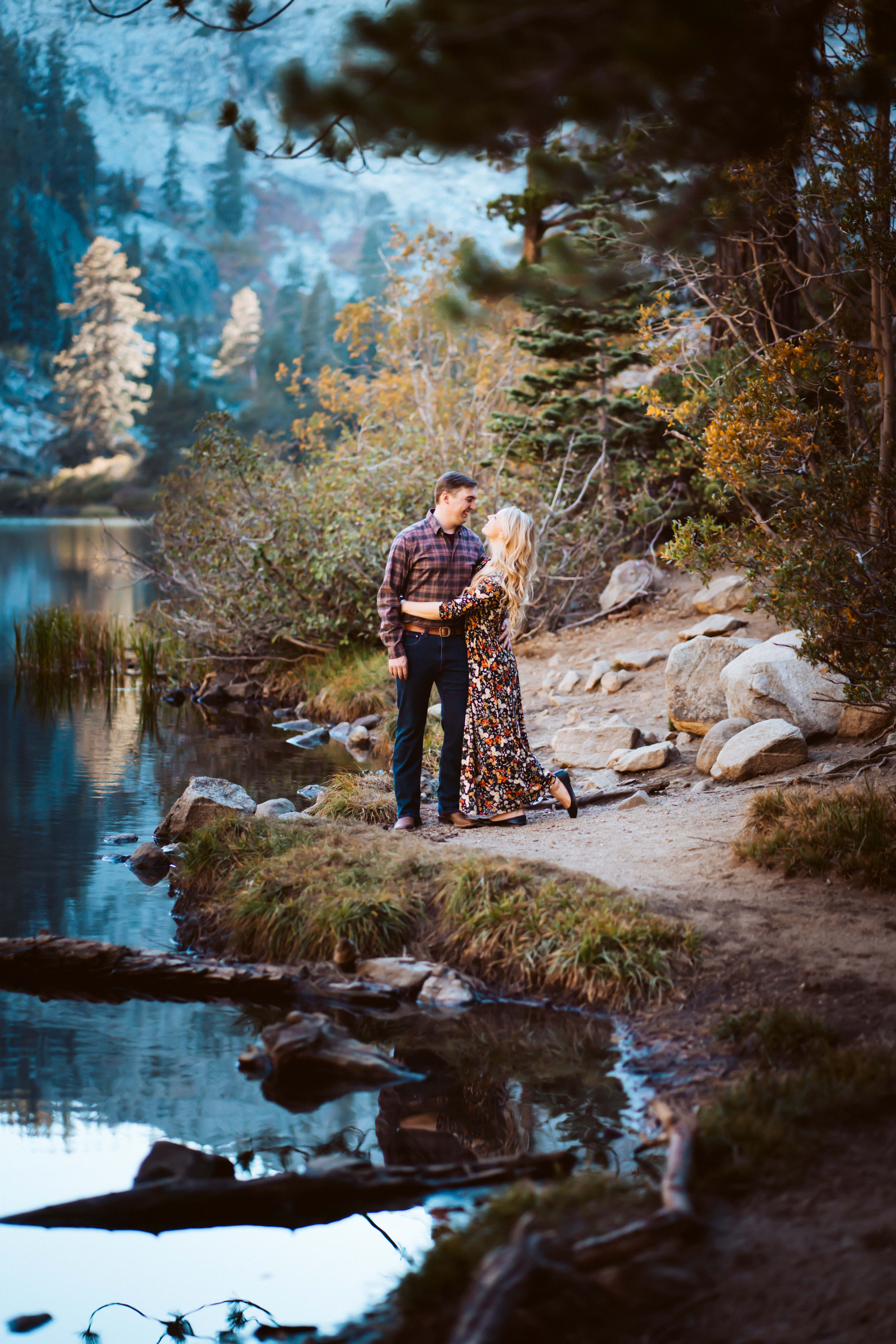 a couple hugging in the mountains with a refection on the lake water in Lake Tahoe