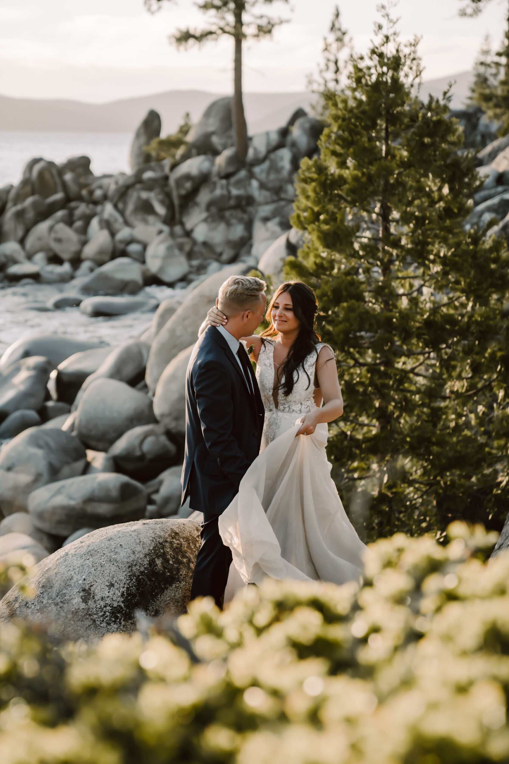 a bride hugging her groom in front of the boulders of Lake Tahoe on her Elopement Day