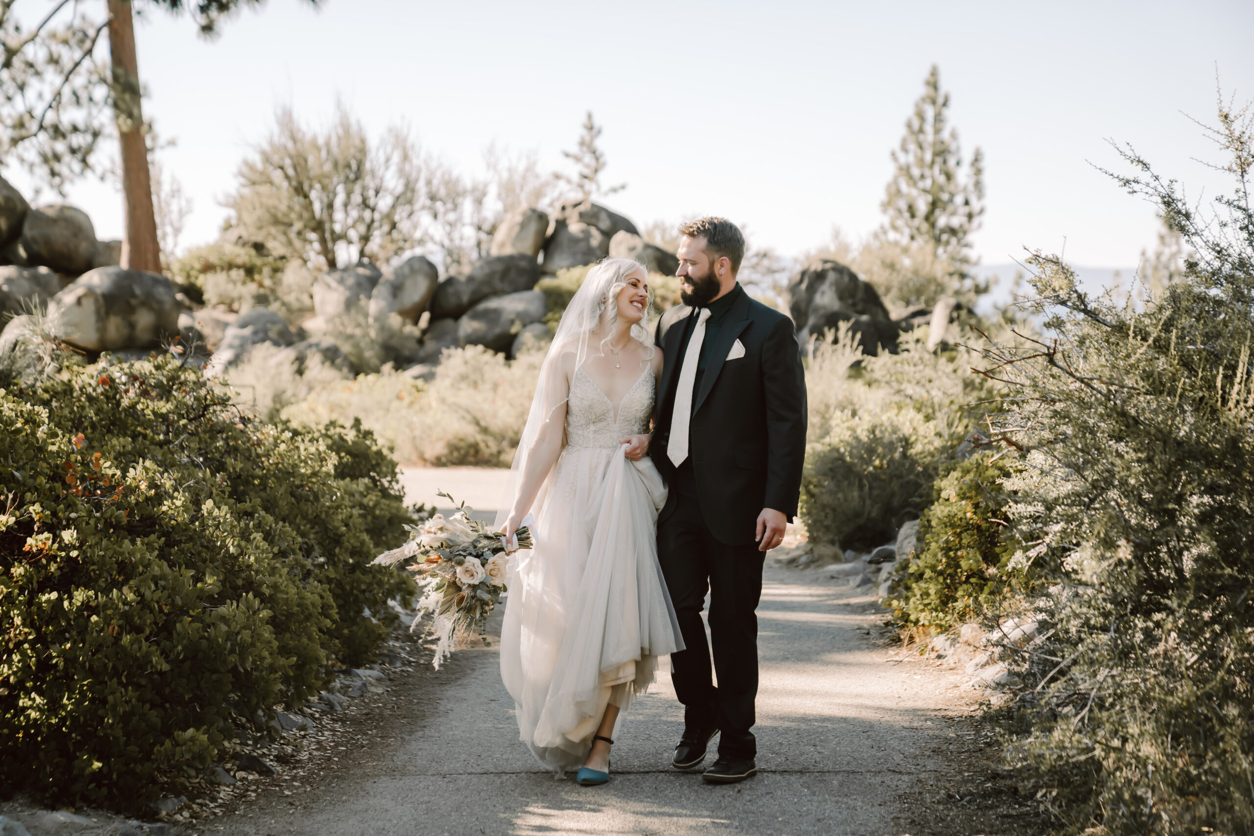 A Wedding couple walking on the path at Logan Shoals Vista Point in Lake Tahoe for their elopement