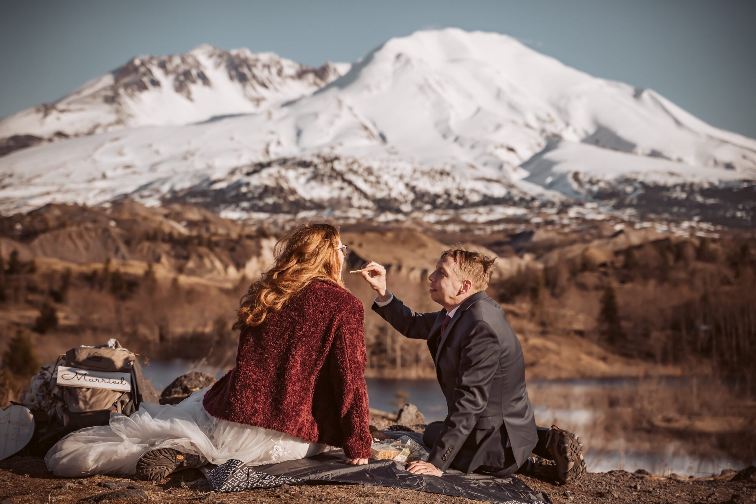 a couple having a picnic in front of Mount Saint Helens for their elopement day