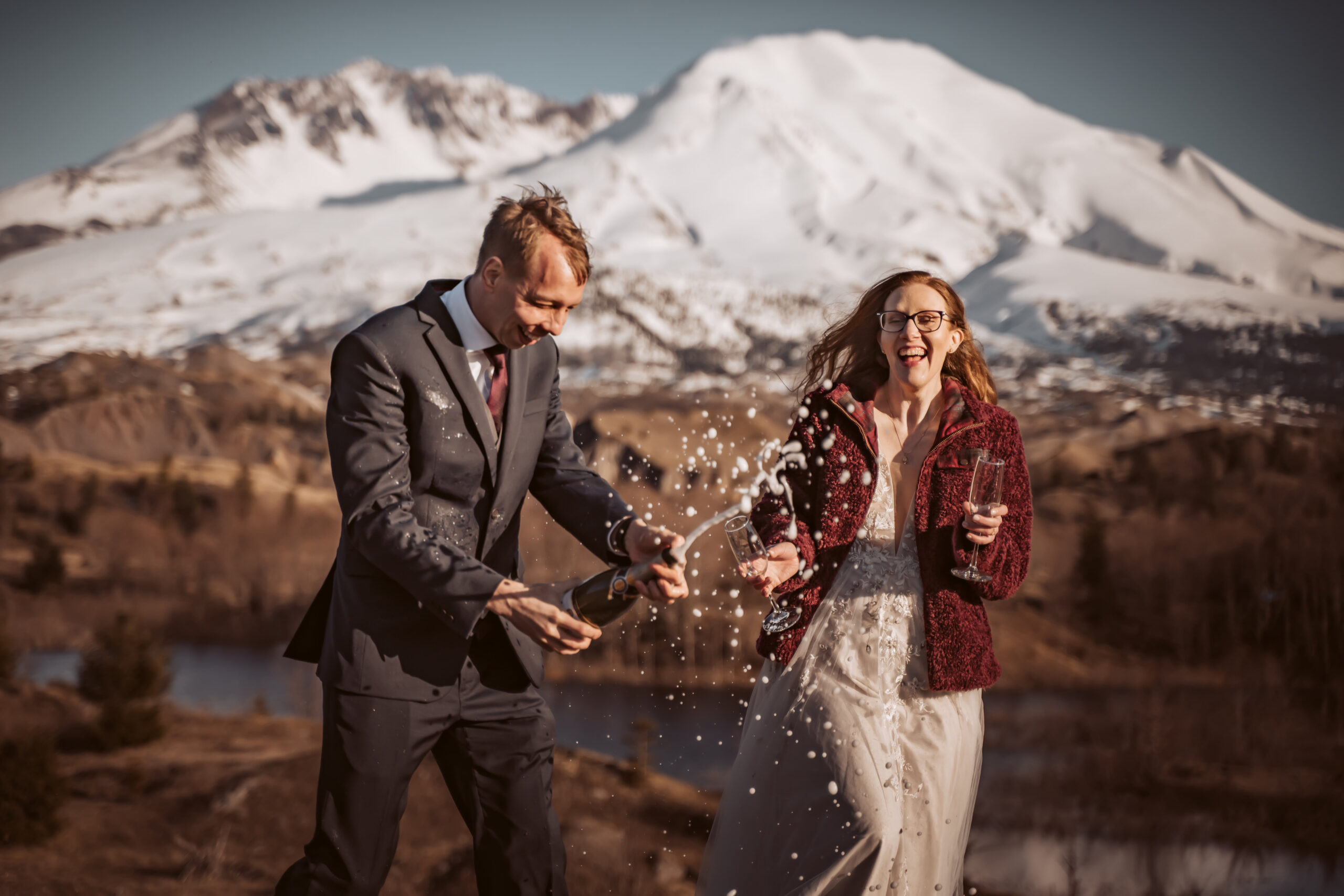  a couple popping champagne for their elopement celebration in Mount Saint Helen's