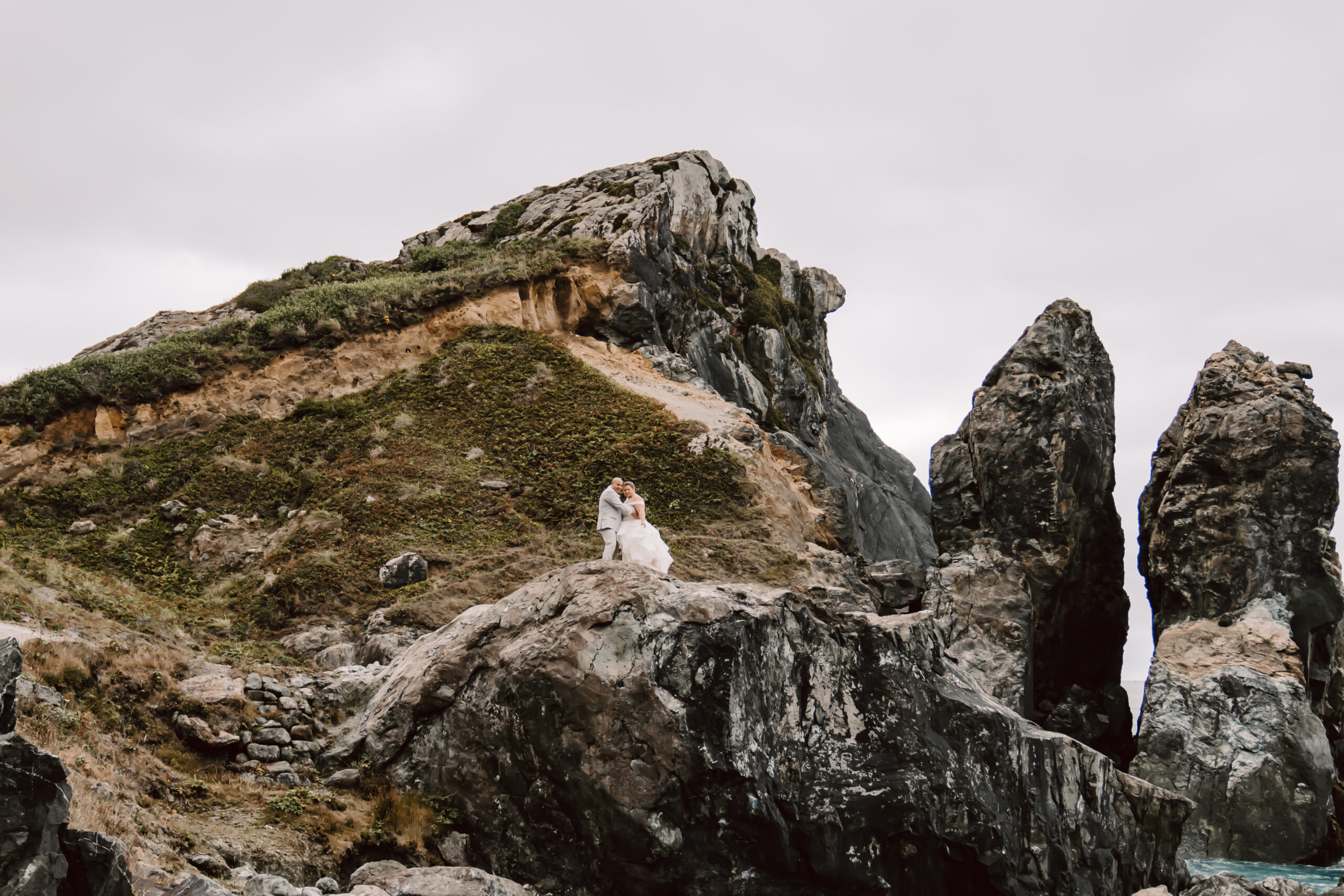 A bride and groom standing on the cliff of the Northern Coast of California for their elopement day 