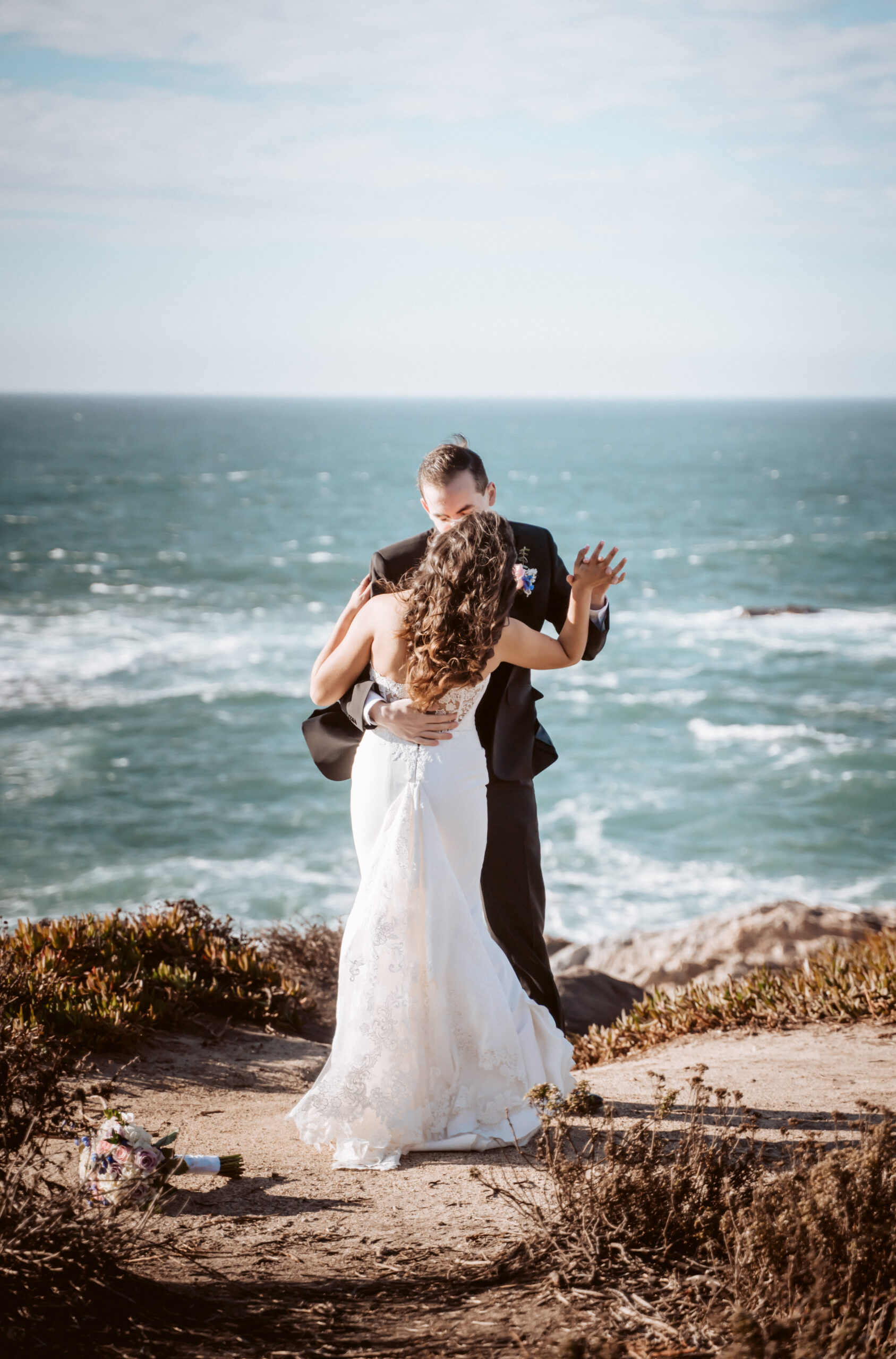 A bride and groom dancing on a cliff overlooking the ocean in Big Sur California for their Elopement day