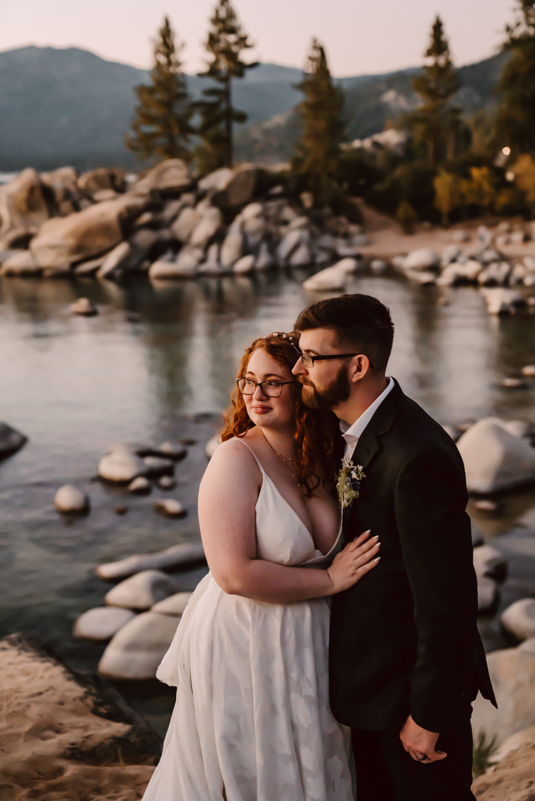 A bride and groom looking off onto the sunset overlooking Sand harbor for their elopement day