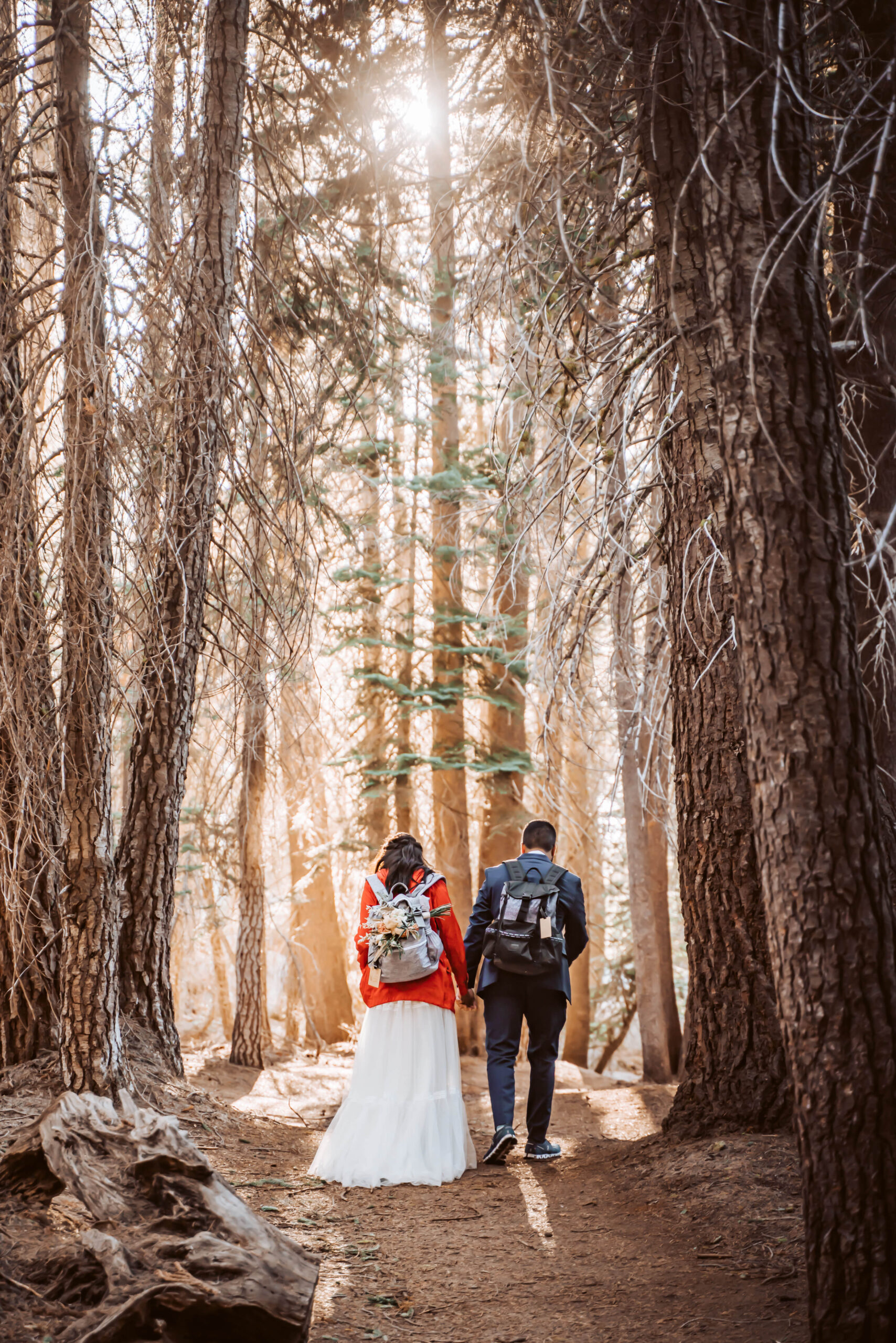 A wedding couple hiking in the trees for their adventure elopement in Yosemite