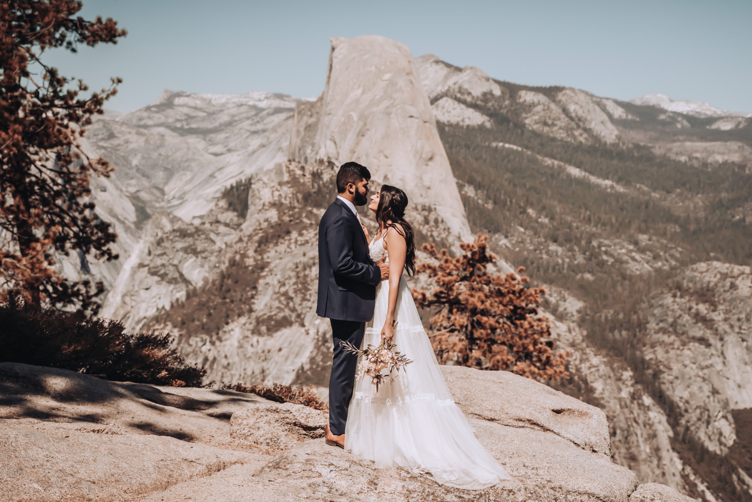 A wedding couple kissing in front of half dome for their elopement in Yosemite