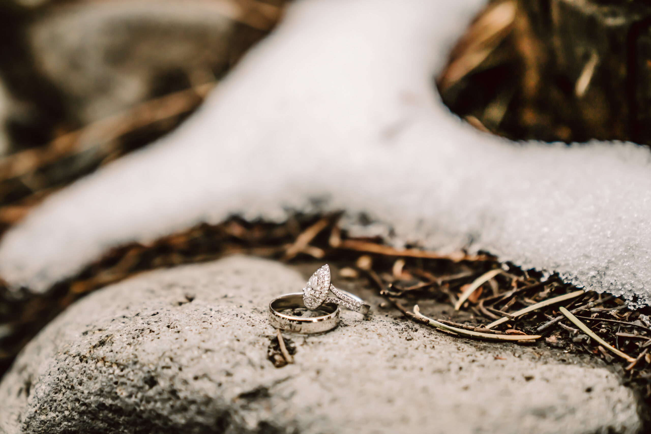 Elopement rings sitting on a rock with snow