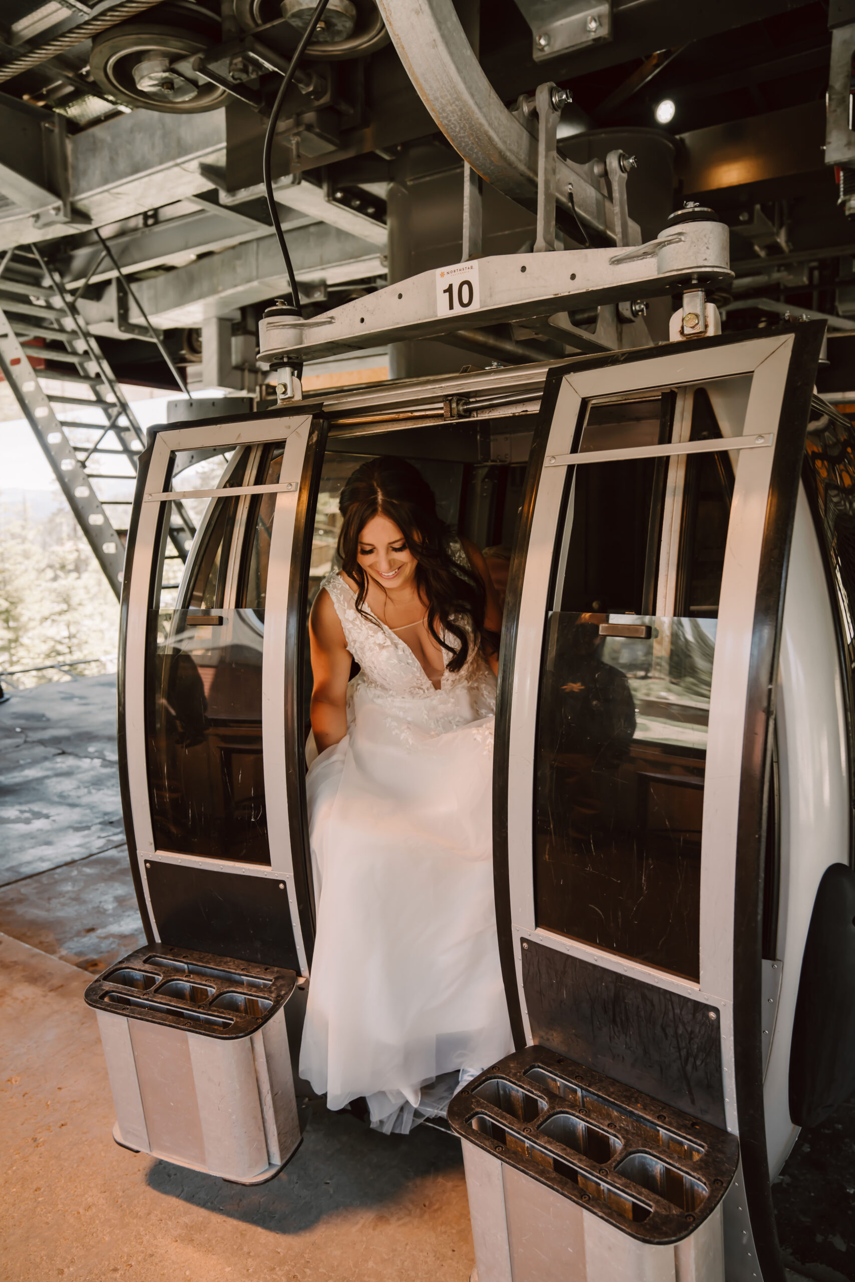 A bride getting out of a gondola ride on her elopement day activity