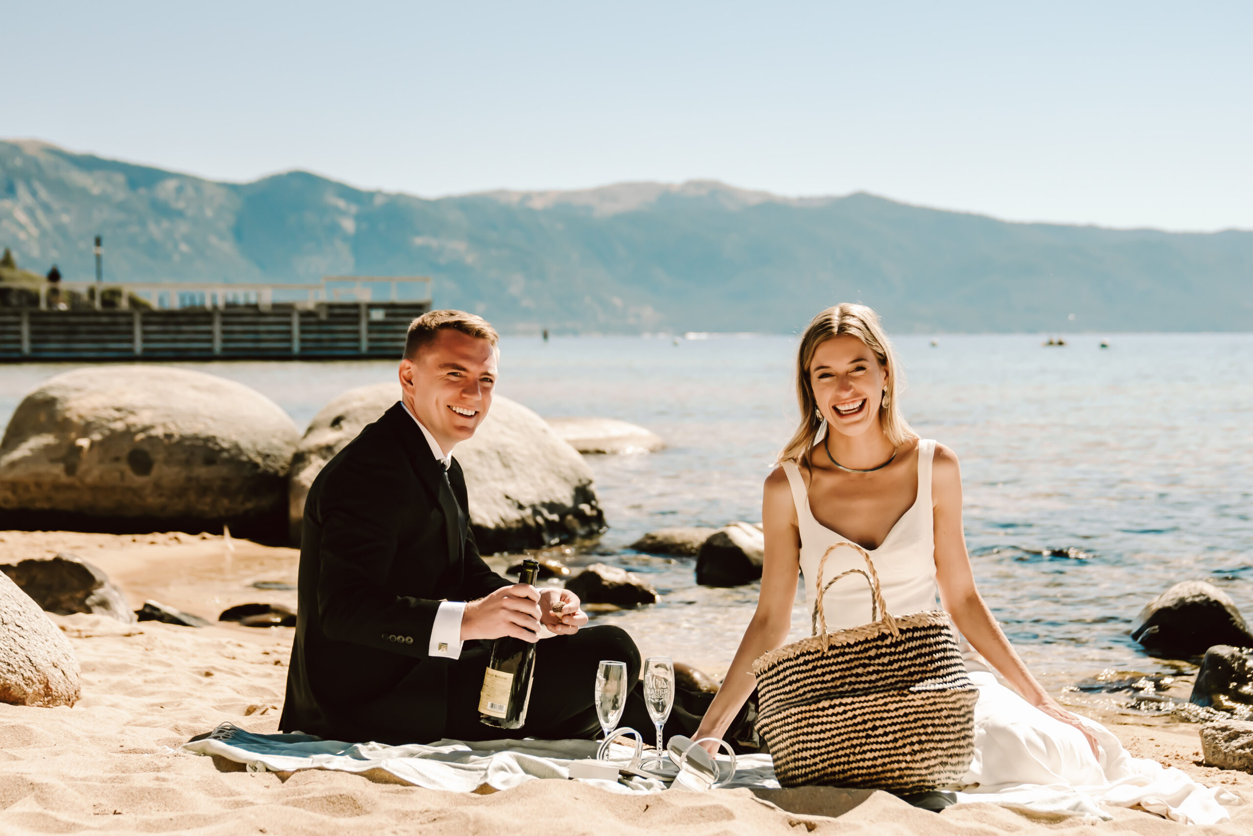A couple having a picnic on the beach for their elopement day activity