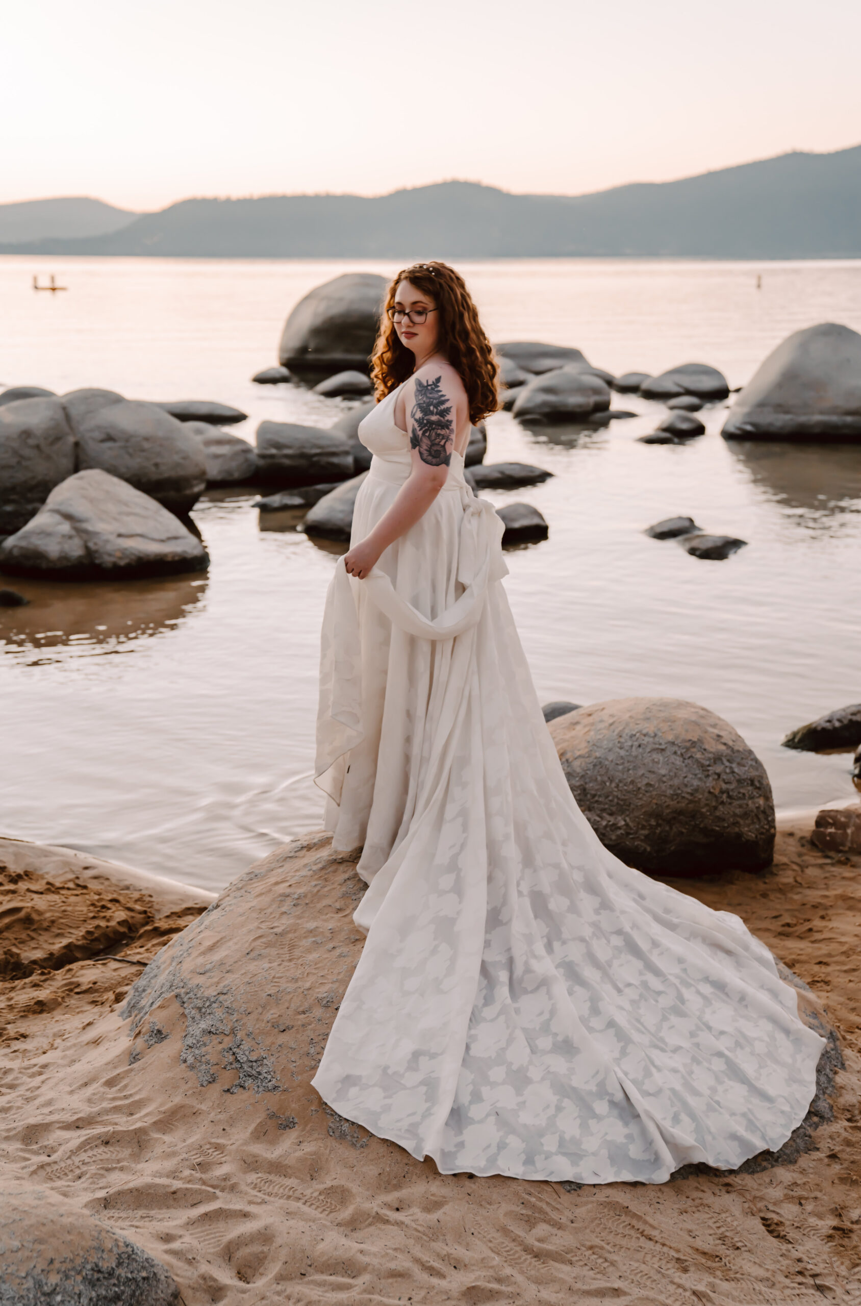 a bride in a beautiful lace elopement dress overlooking Sand Harbor in Lake Tahoe