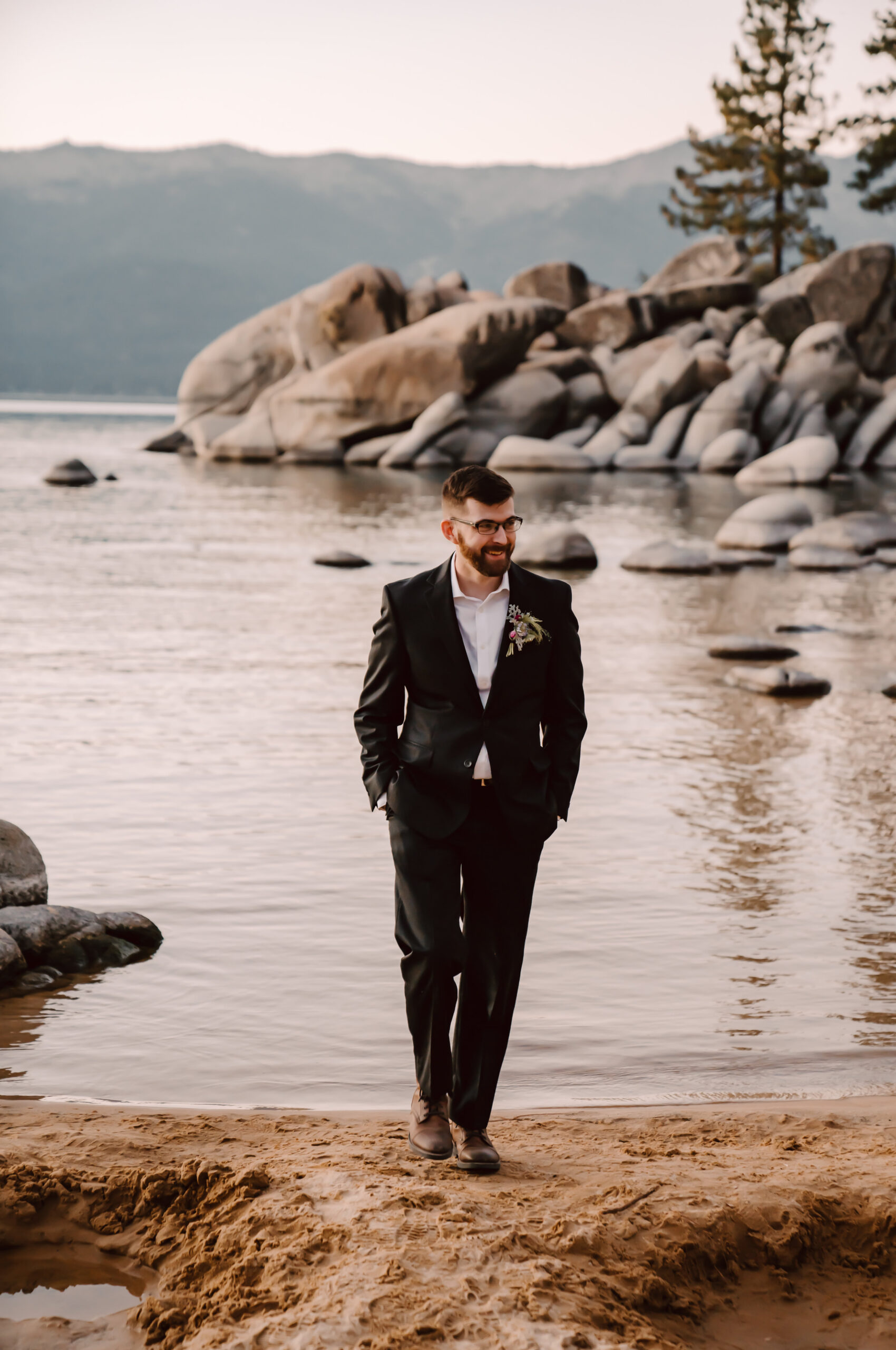 A groom wearing a black suit for his elopement day