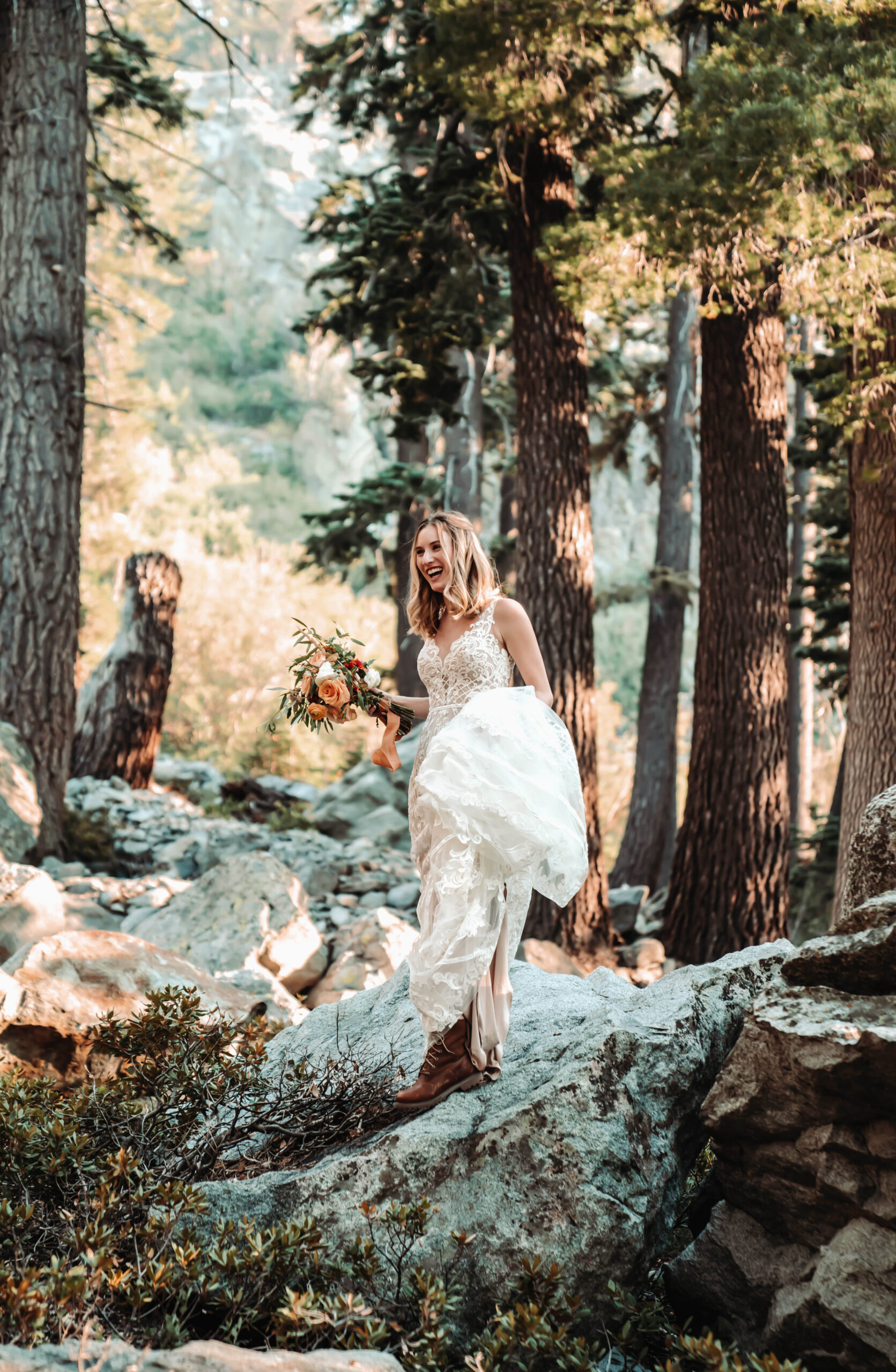 A bride walking on the boulders in Lake Tahoe holding up her dress on her elopement day