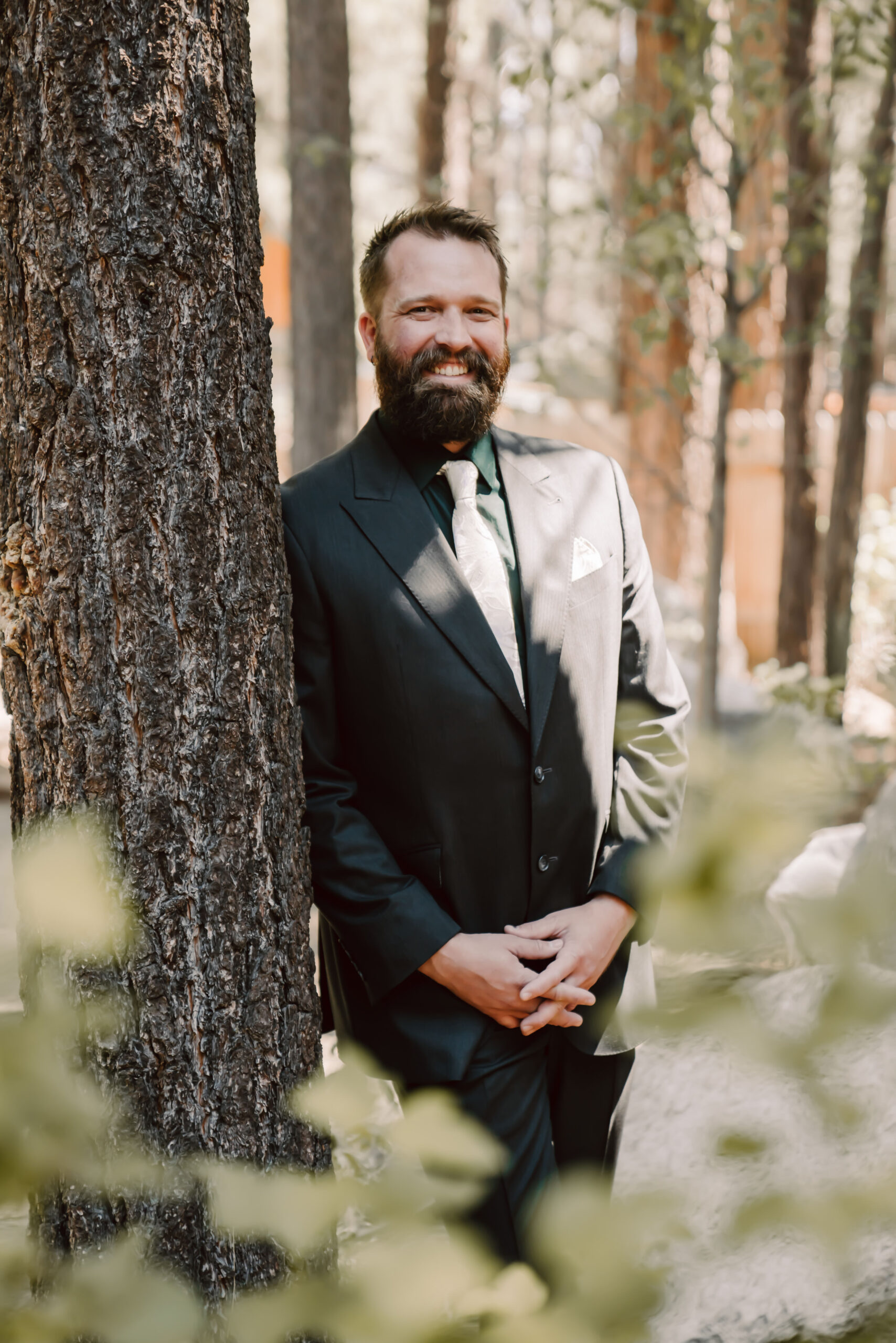 a groom wearing a full black elopement suit with white tie 