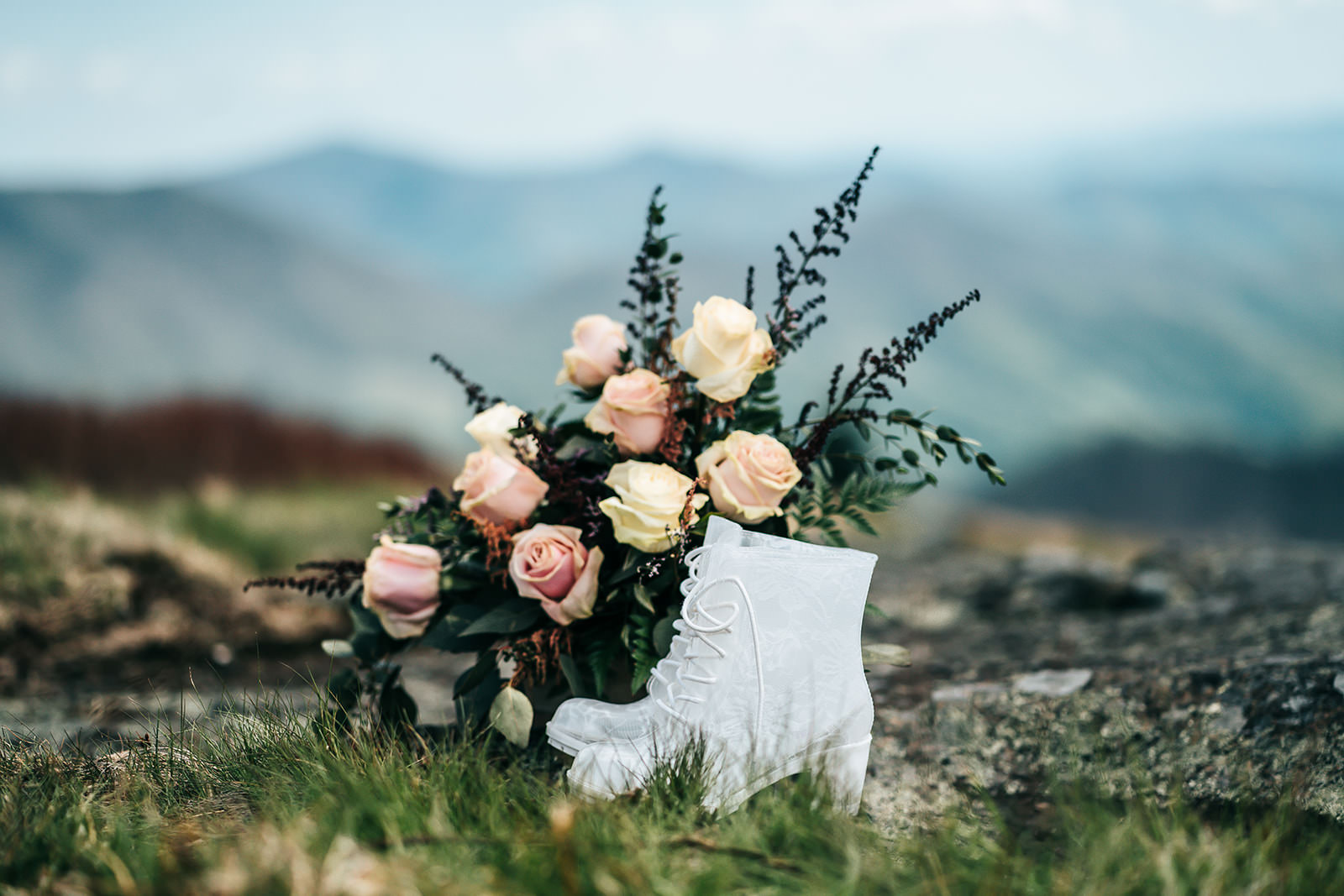 White clear elopement hiking boots in front of a beautiful bouquet