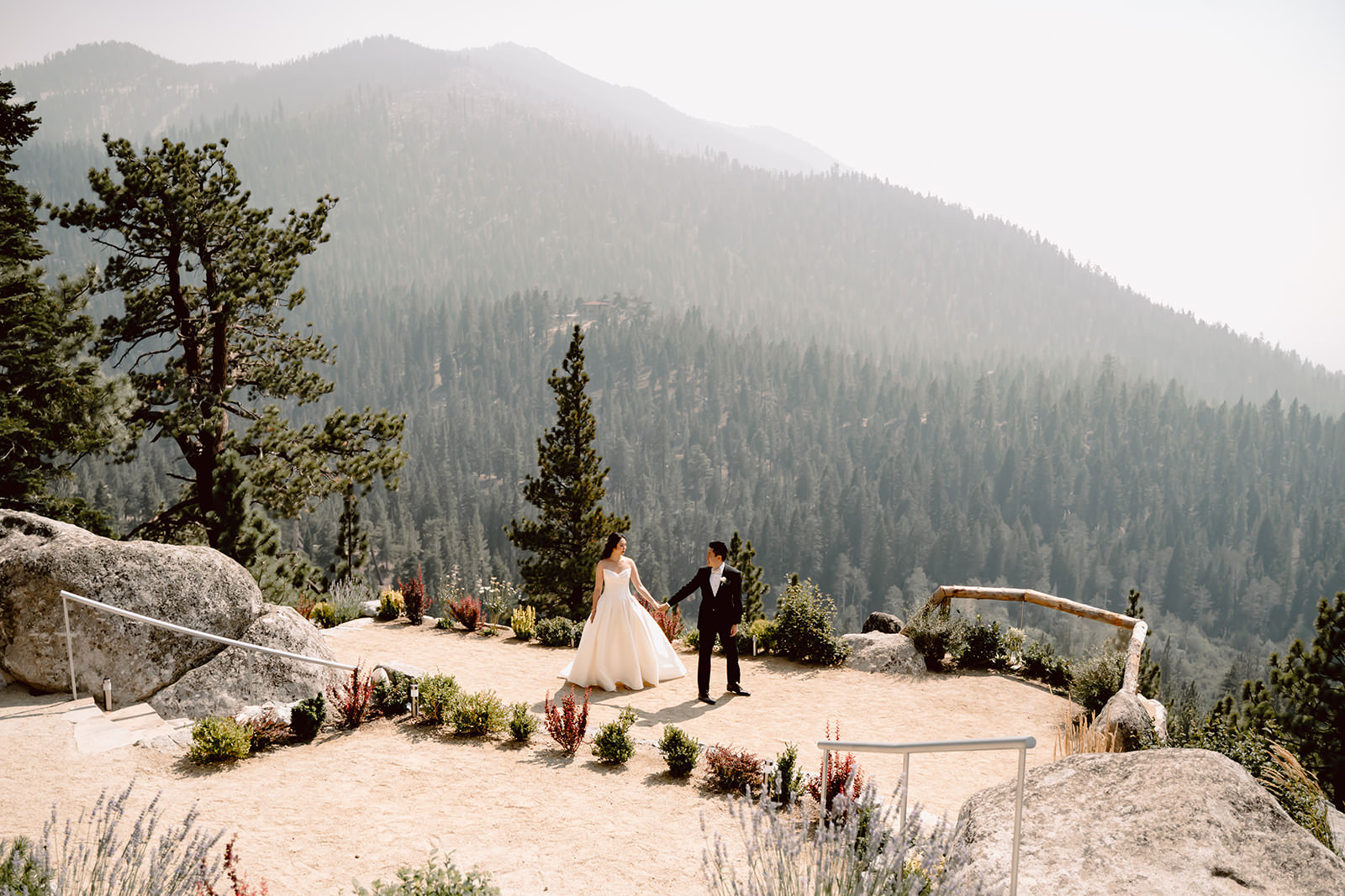 A bride and groom walking at the viewpoint of the Tahoe Blue Estate in Lake Tahoe for their wedding day