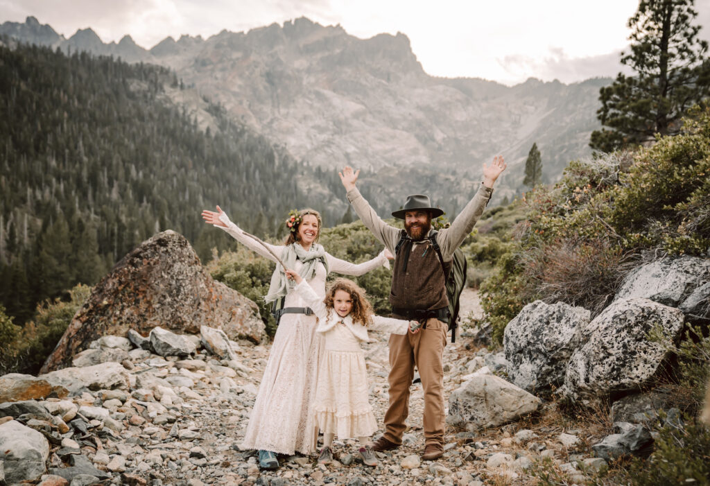 A bride and groom with their daughter on their hiking elopement day in Northern California in the mountains
