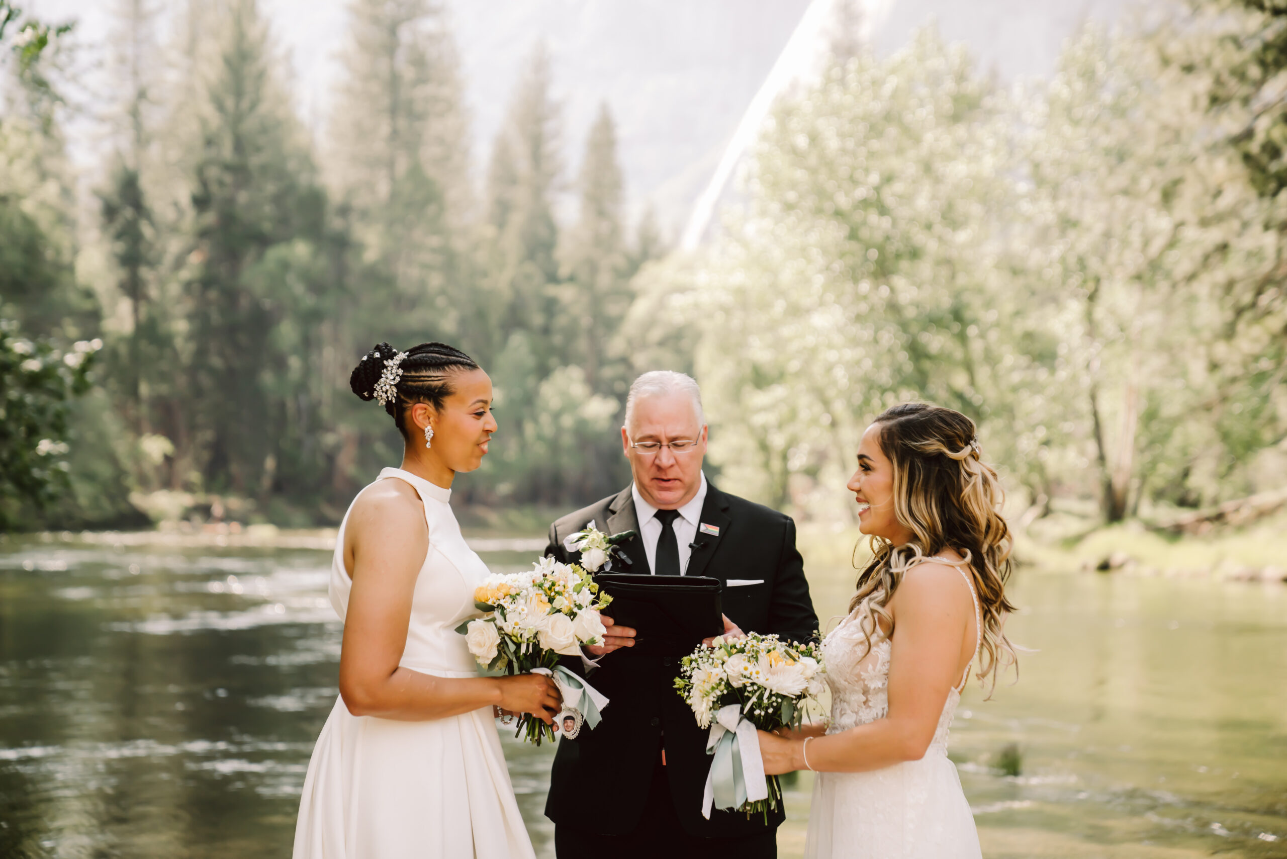 Two brides in white dresses getting married in Yosemite with the trees and the mountains as the backdrop