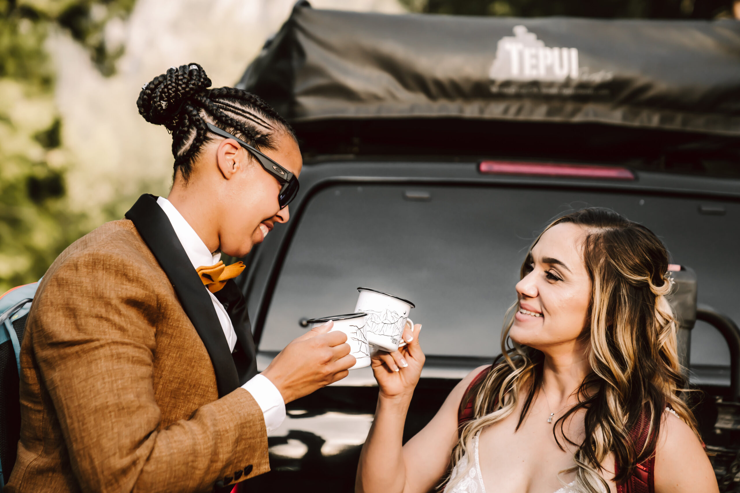 Two bride cheersing with their mountain cups and their truck in the background during their Yosemite Elopement