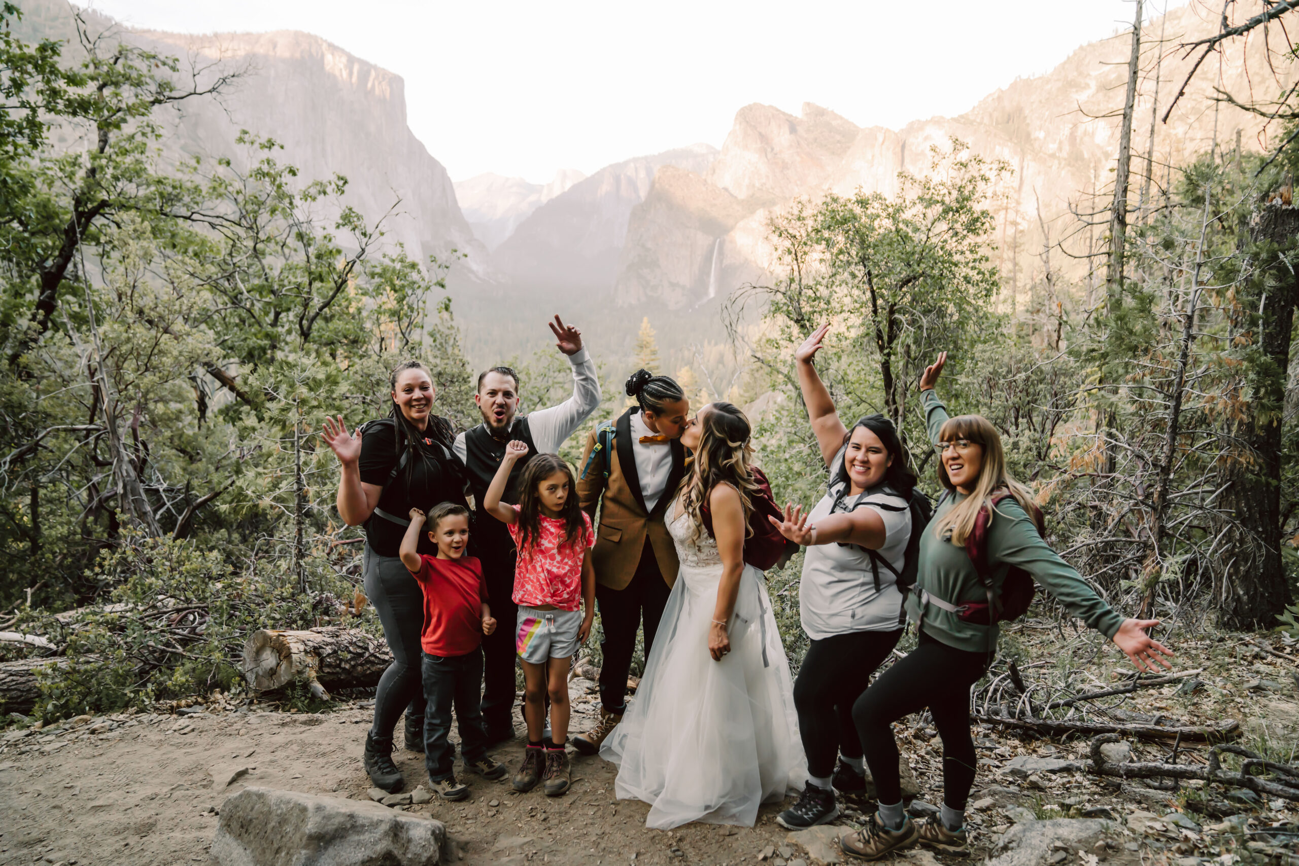 A group of friends surrounding an elopement couple overlooking Tunnel View in Yosemite for their elopement day hike