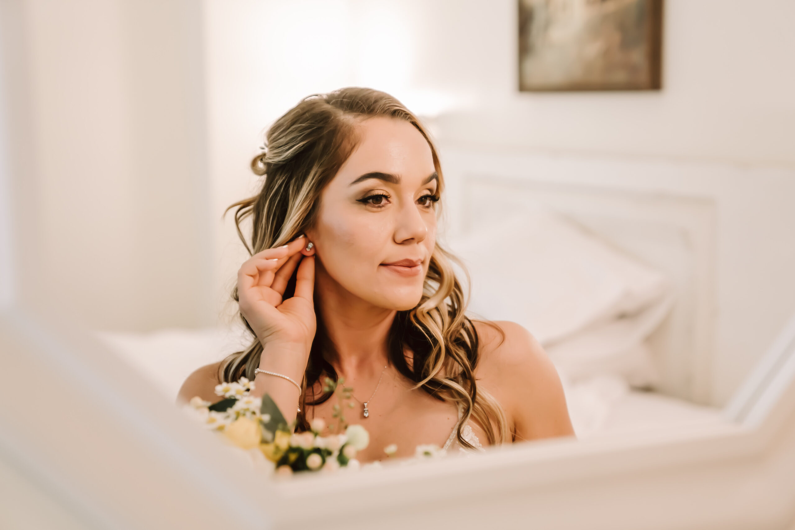 A bride looking in the mirror putting her earrings on and getting ready for her Yosemite Elopement