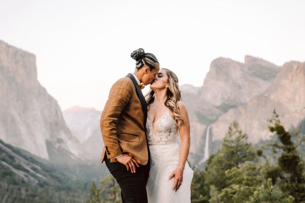 two brides kissing in front of Tunnel view during blue hour on their Yosemite Elopement day 