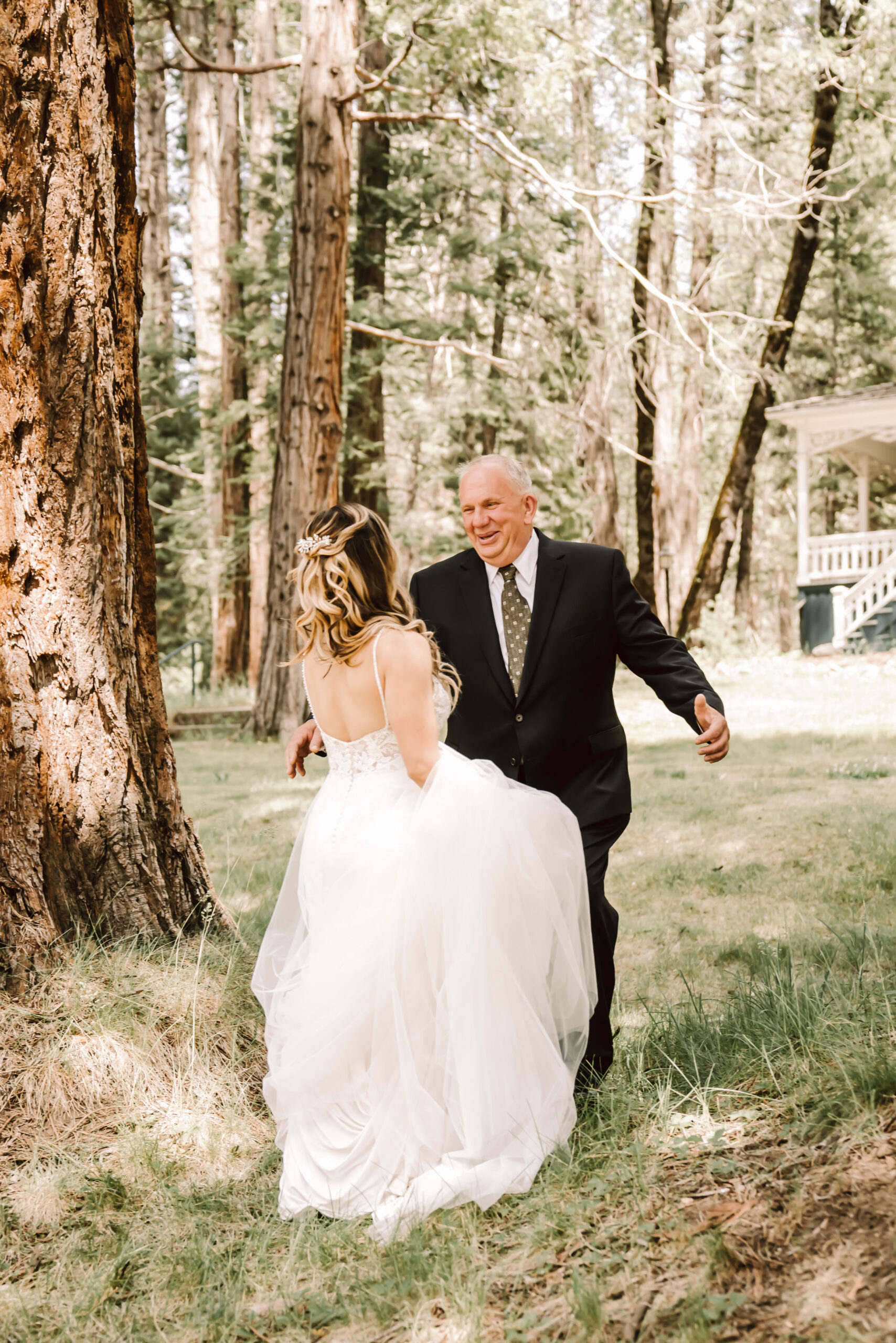 a dad seeing his daughter for first look on her wedding day surrounded by trees in Yosemite National Park