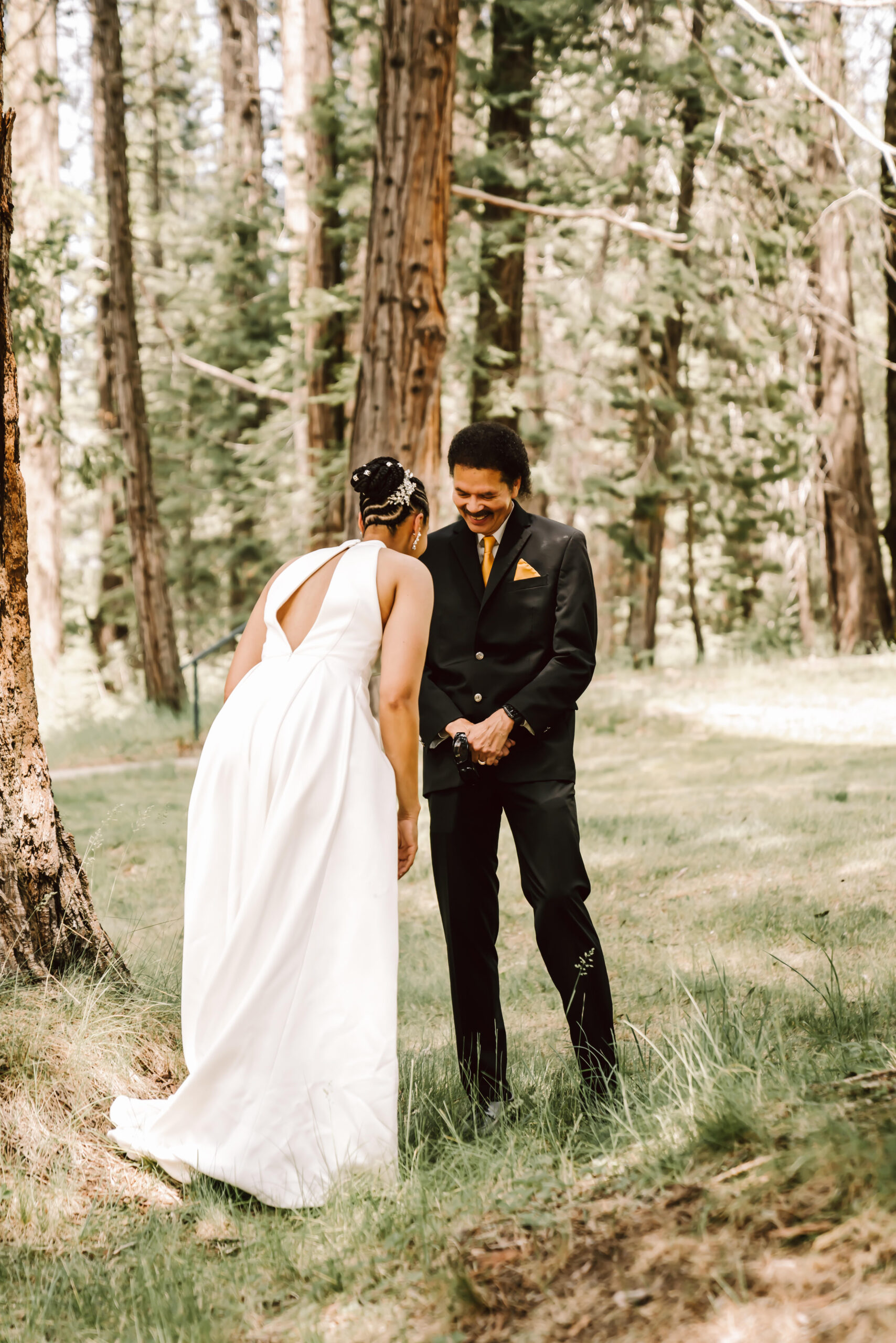 A dad seeing his daughter for first look in the forest for her wedding day in Yosemite National Park