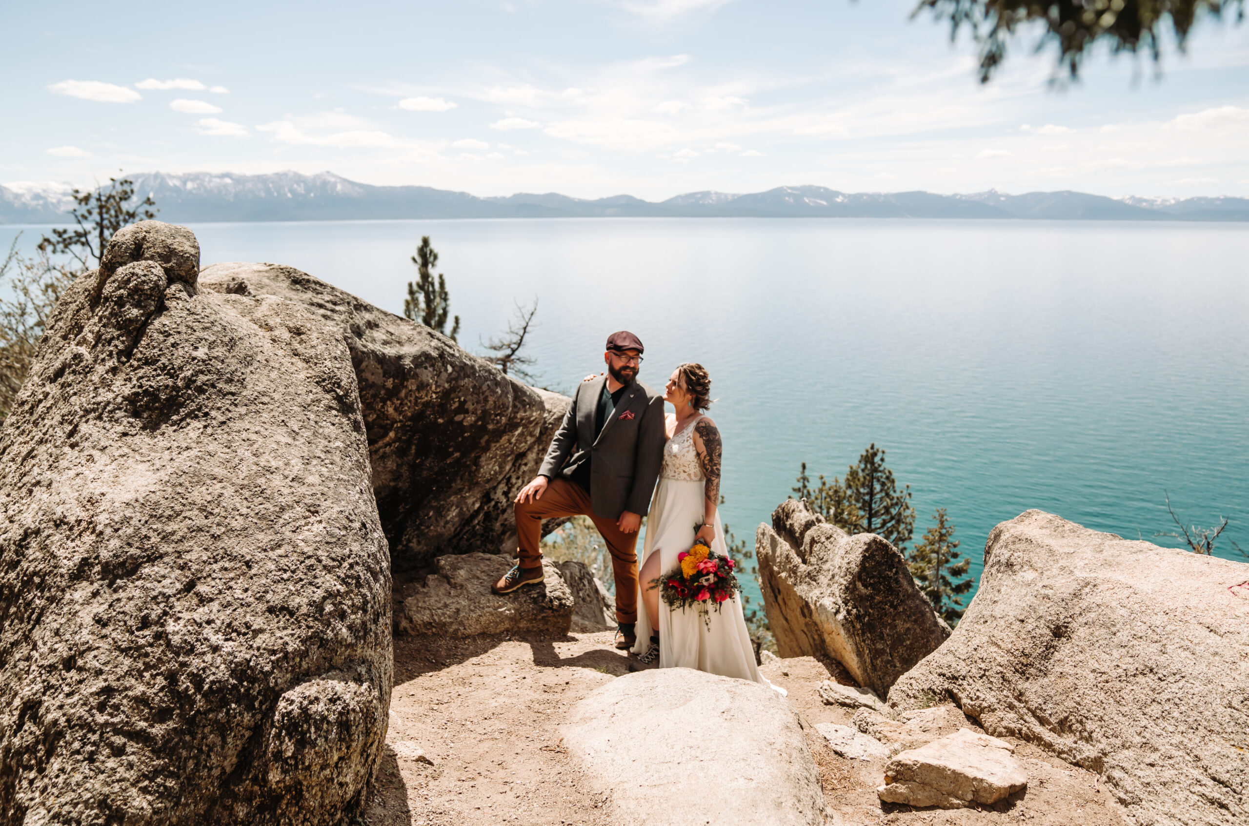 A wedding couple standing on a rock overlooking Lake Tahoe for their wedding day