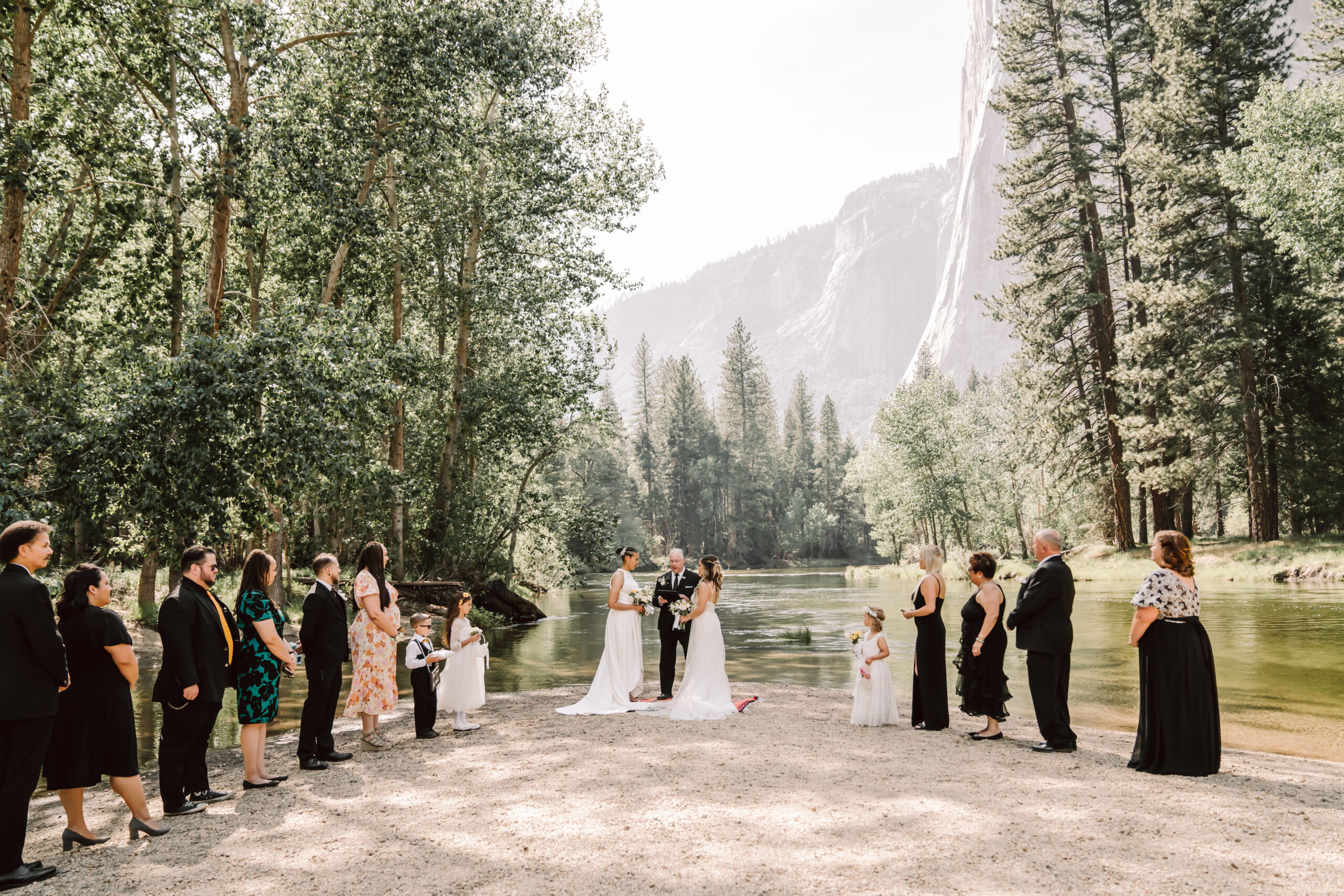 Two brides getting married in Yosemite at Cathedral Beach surrounded by friends and family