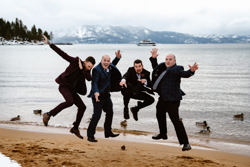 A groom and his guys jumping on the snow covered beach for his wedding day