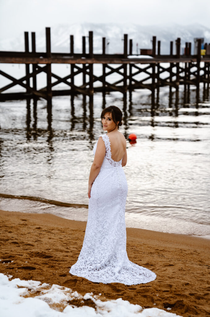  A bride standing with her back to us in front of the pier in Zephyr Cove in Lake Tahoe on her wedding day