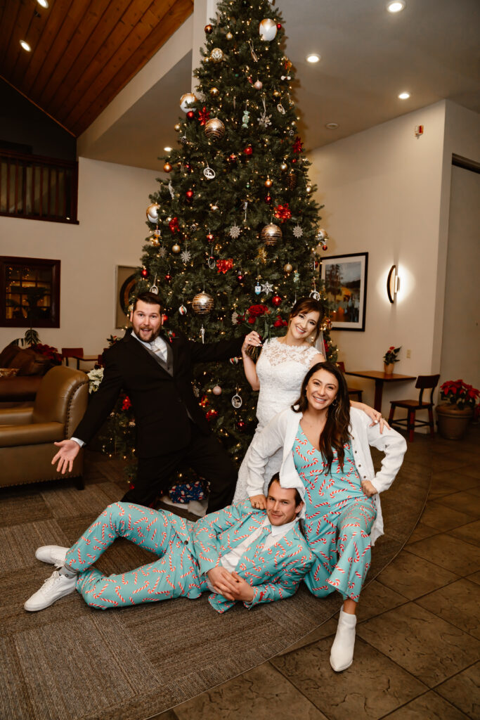 A wedding couple and their friends next to a Christmas Tree