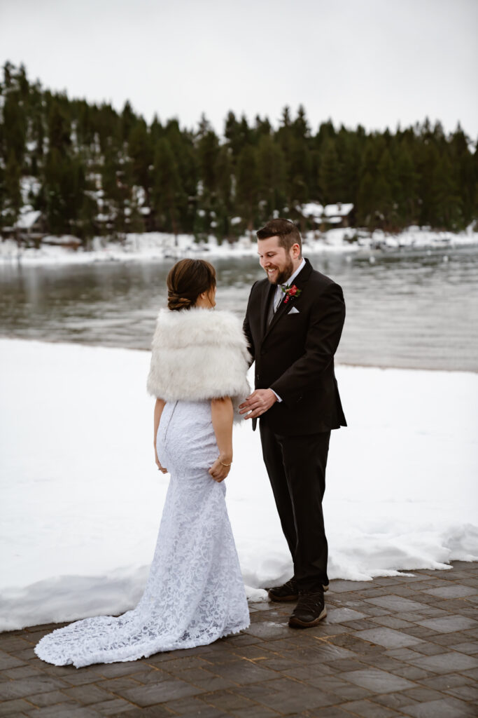A groom seeing his bride for the first time during first look in the snow
