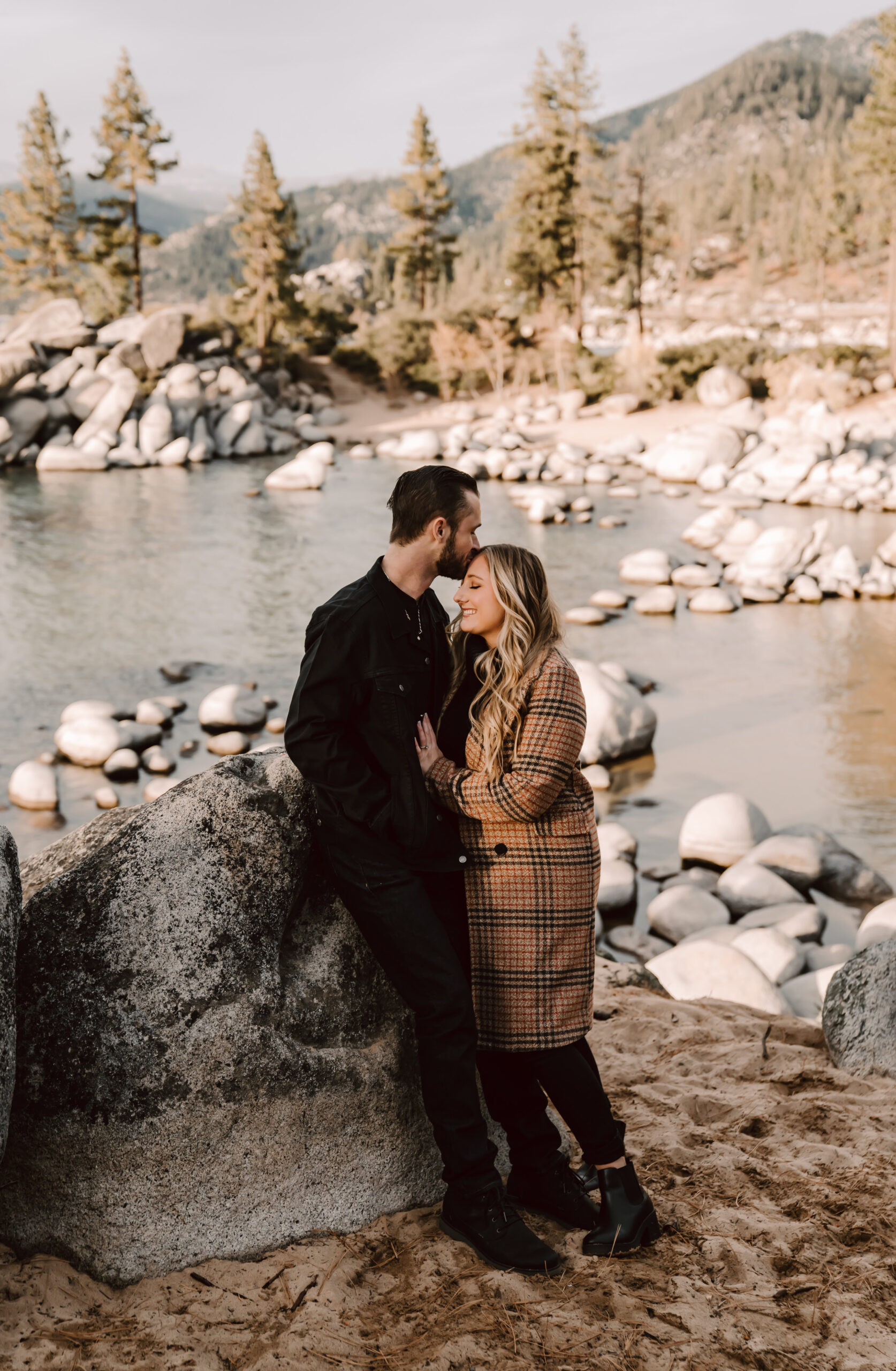 a guy kissing his girl on the forehead overlooking Sand Harbor in Lake Tahoe