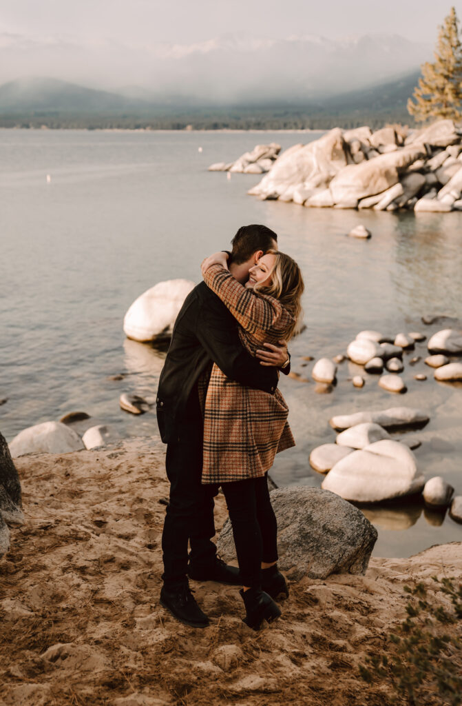 a couple hugging in front of Sand Harbor in Lake Tahoe