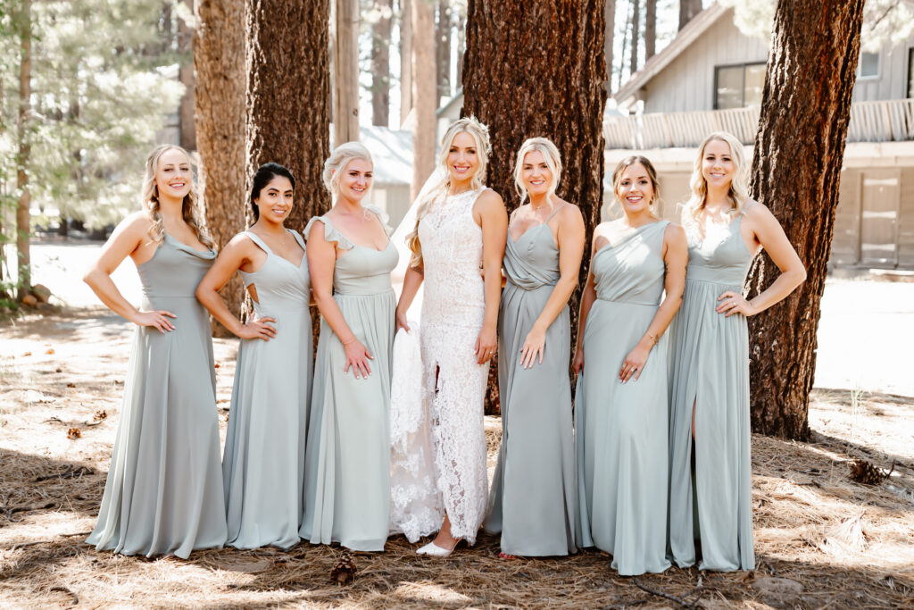 A bride and her bridesmaids standing in the forest for their bridal portraits on her wedding day