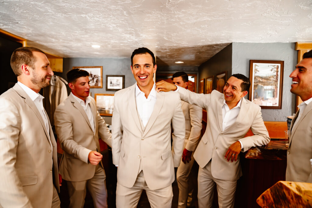 a groom getting congratulated by his groomsmen when he is getting ready for his wedding