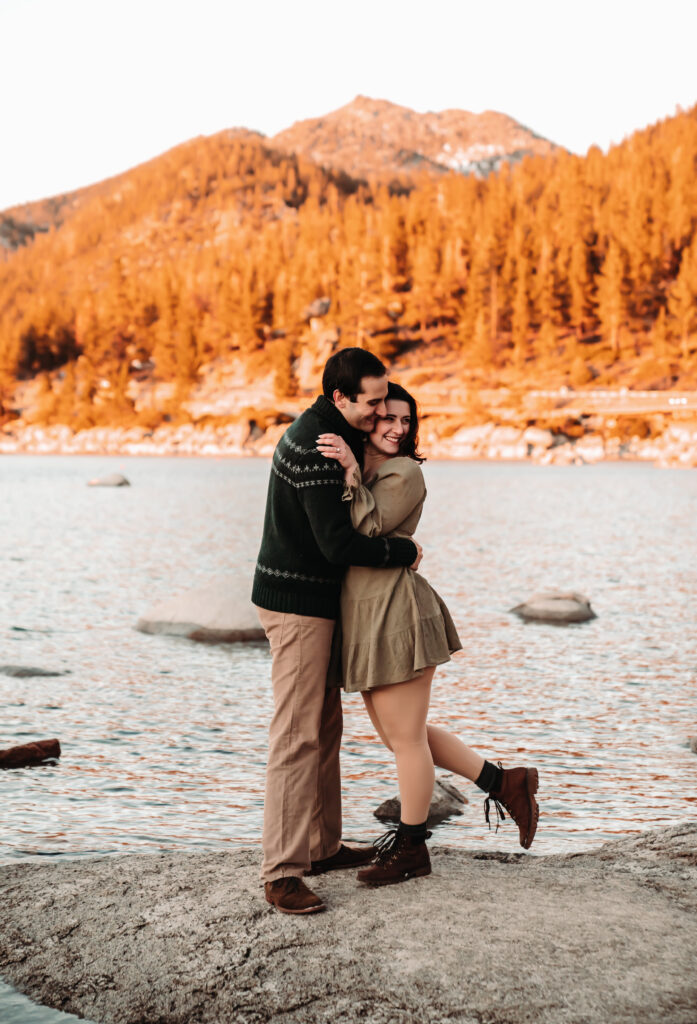 a couple standing in front of the mountains in lake Tahoe during sunset engagement photos