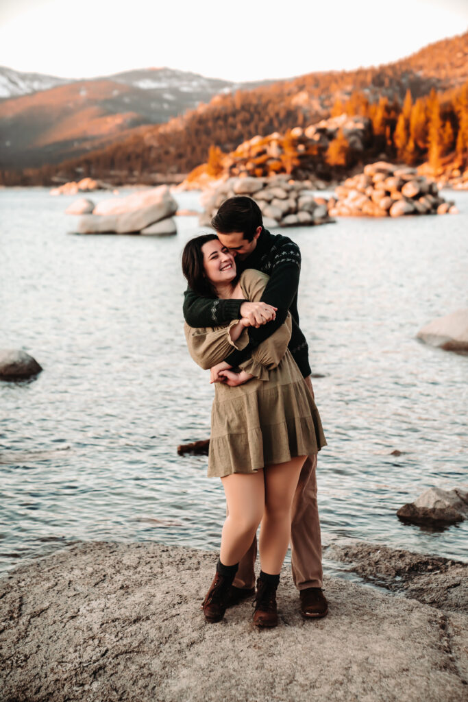 a couple hugging in front of alpenglow in Lake Tahoe during their engagement photo session