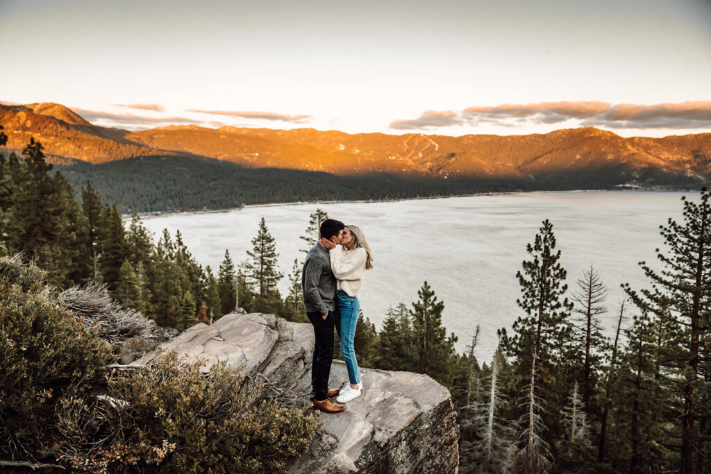 a couple standing on some boulders in Lake Tahoe for their engagement Photos