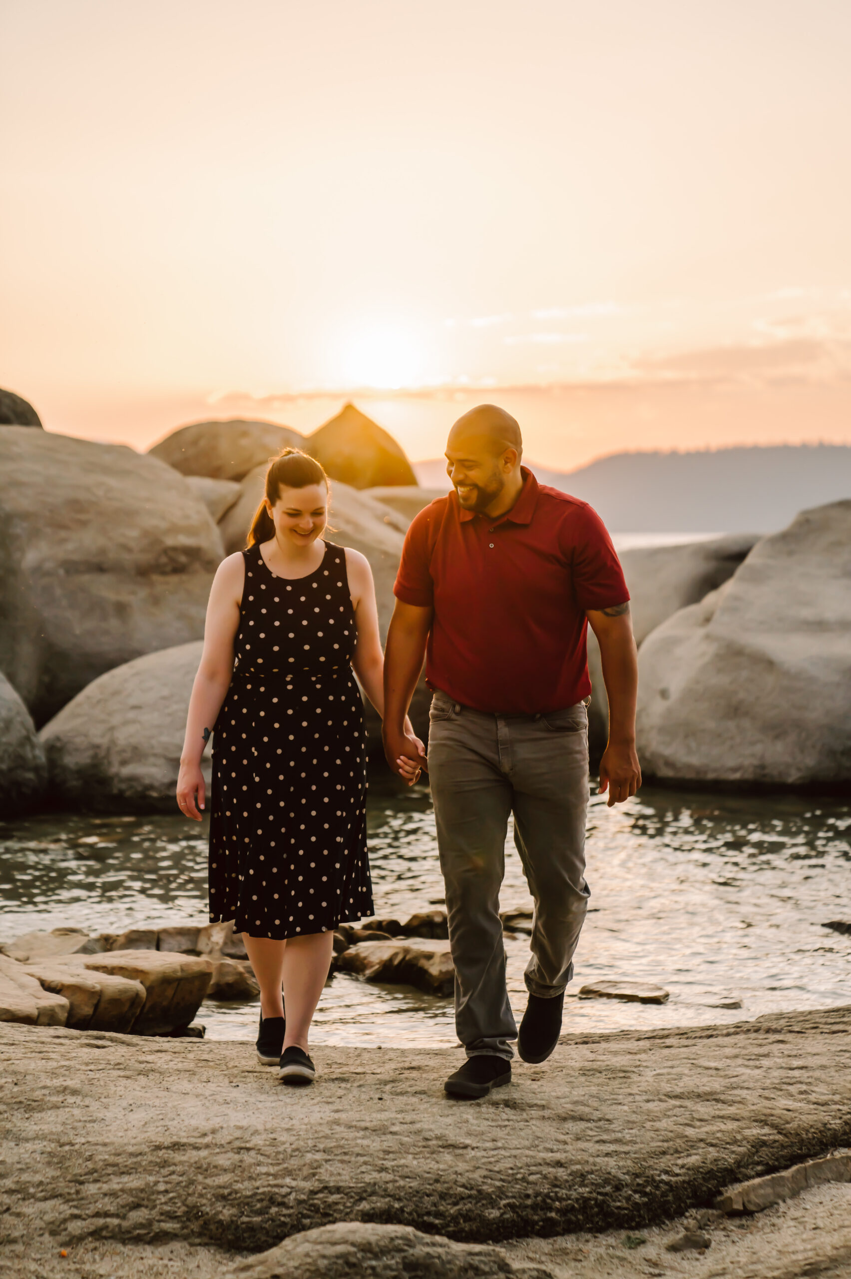 a couple walking on the beach at sunset for their engagement photo session in Tahoe