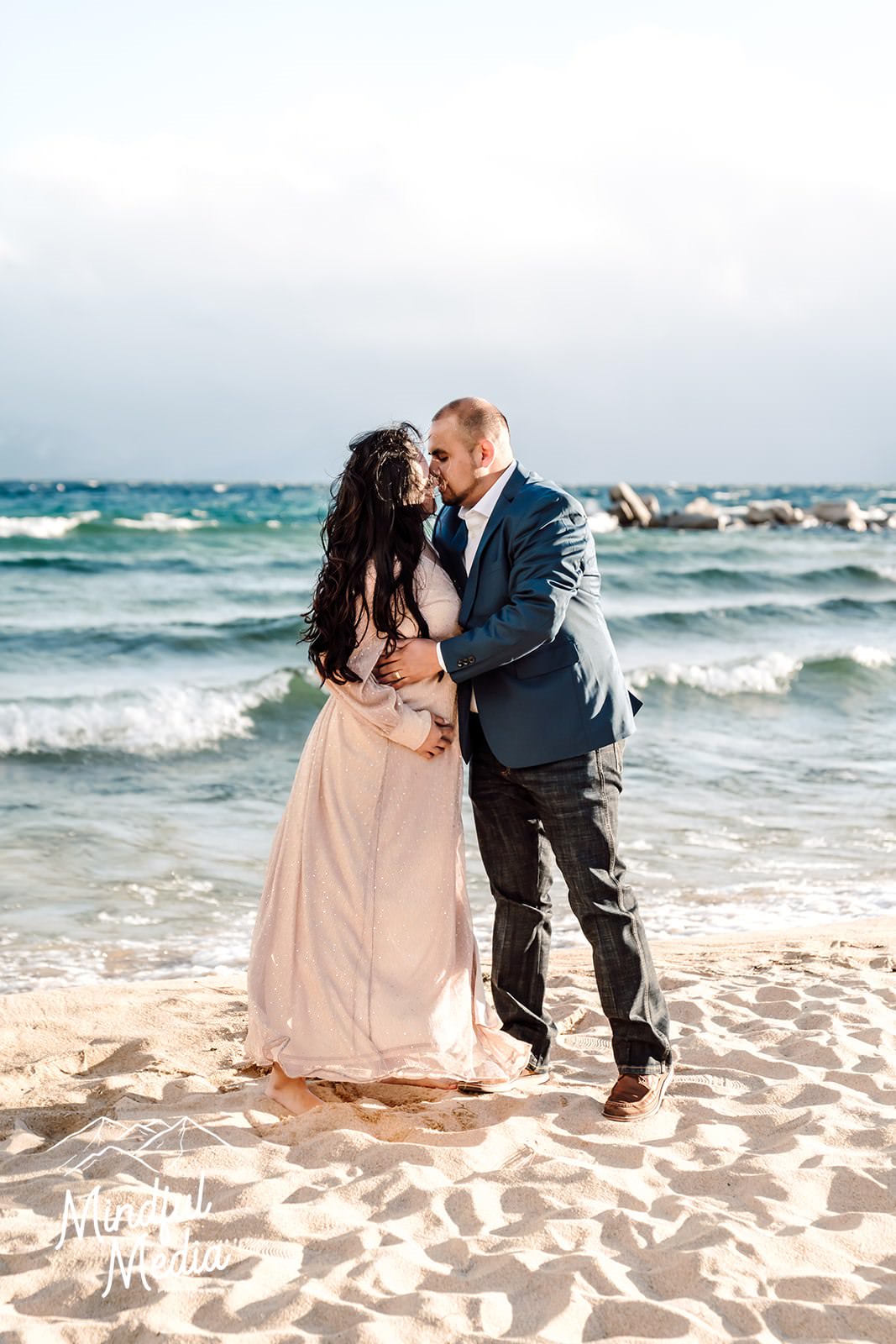 a couple kissing in front of the turquoise water of Lake Tahoe