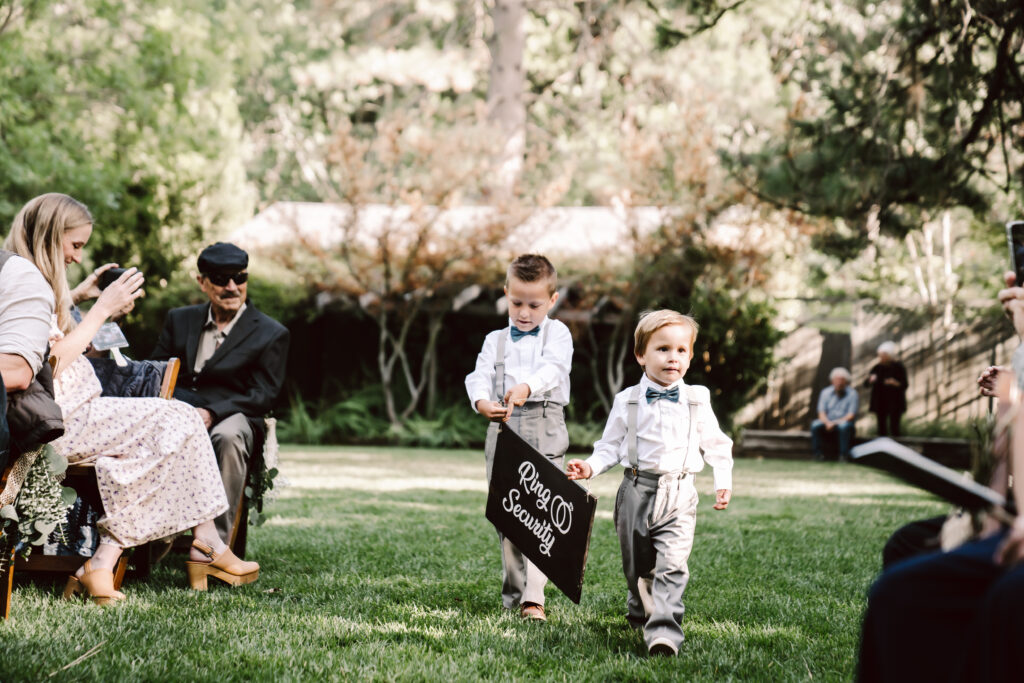 two little ring bearers walking down the aisle for the wedding ceremony 