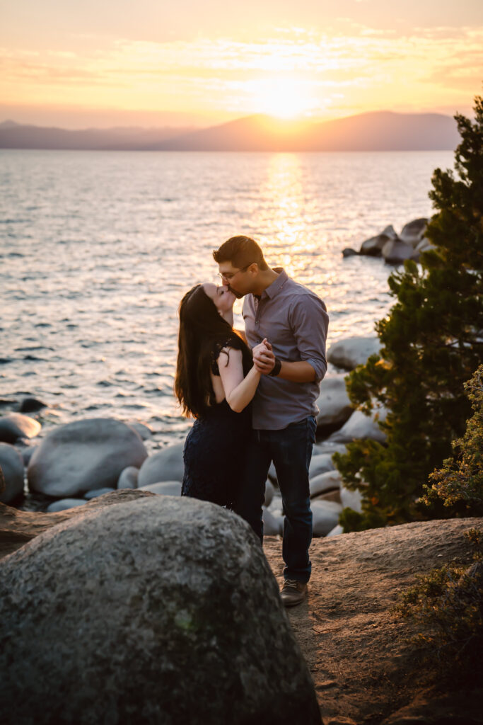 a couple kissing with the sunset above the mountains at Lake Tahoe