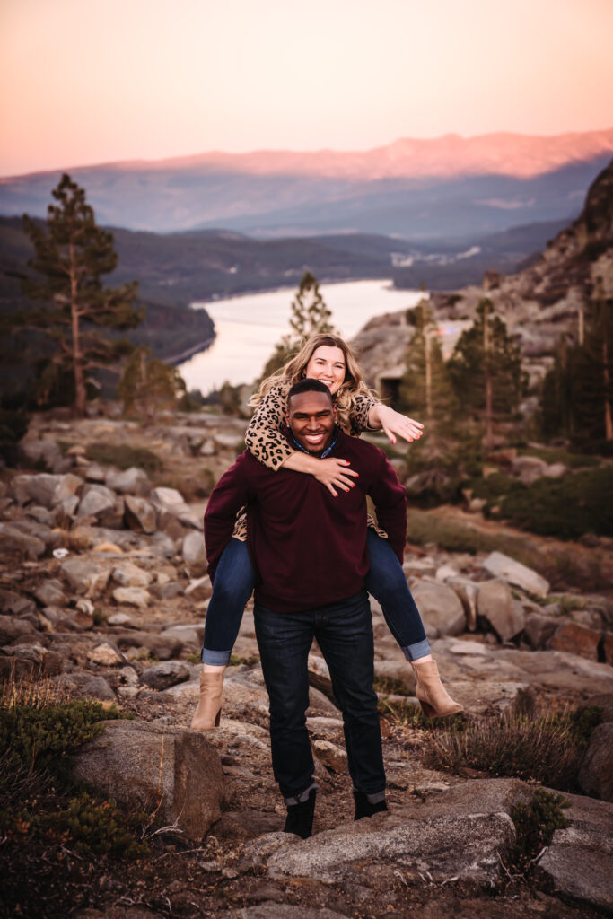 a girl on her boyfriends back showing her new engagement ring during their photo session in Truckee