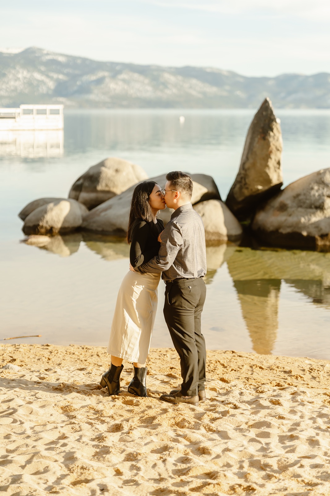 Man and woman kiss during engagement session at Sand Harbor in Lake Tahoe