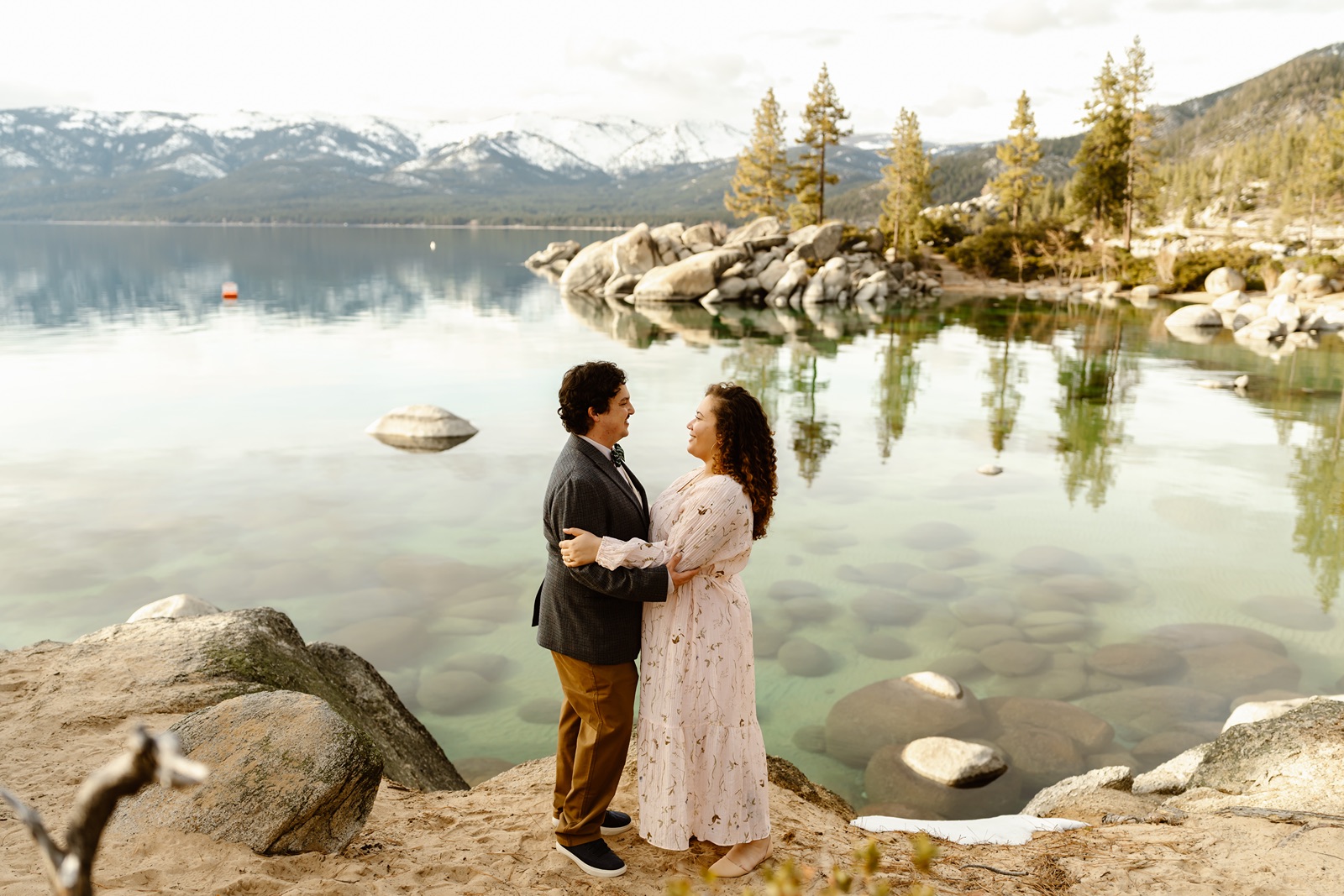 Couple smiles at each other with Lake Tahoe backdrop